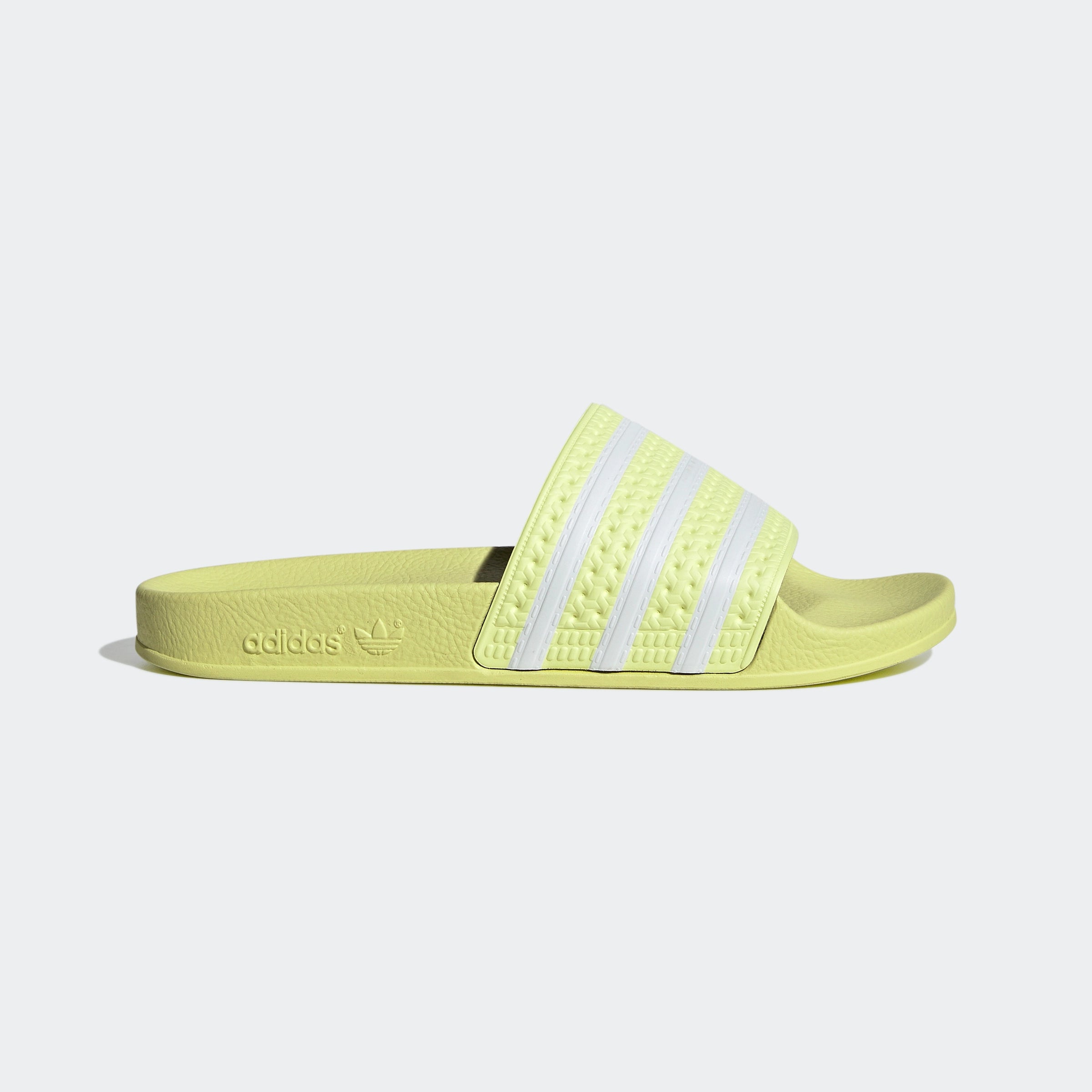 "Gelbe Adidas Adilette für Damen mit weißen Details. Klassische Badesandale mit breitem Riemen und weißem Adidas Logo. Bequemes, leichtes Material."