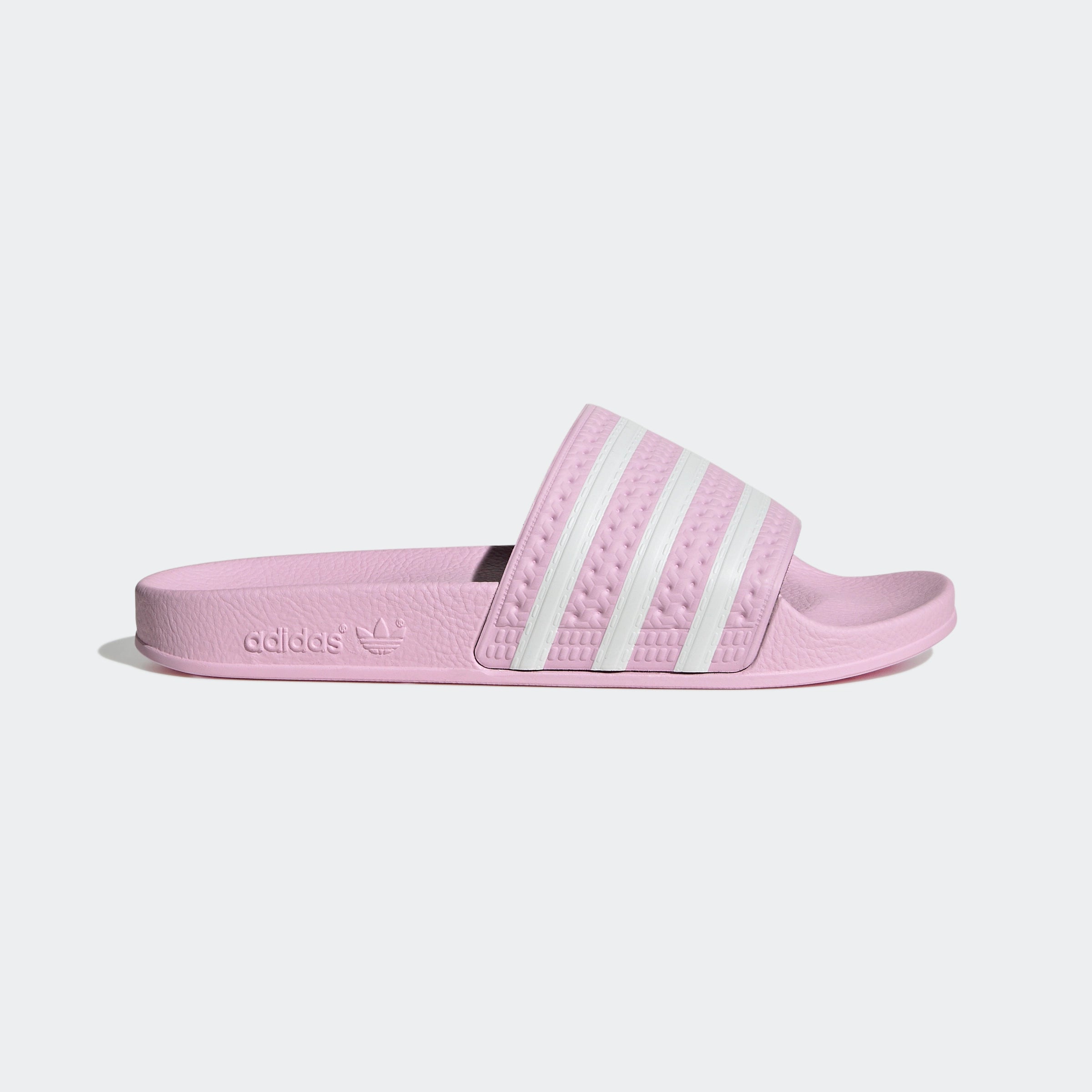 "Rosafarbene Adidas Adilette für Damen mit weißen Details. Klassische Badesandale mit breitem Riemen und weißem Adidas Logo. Bequemes, leichtes Material."