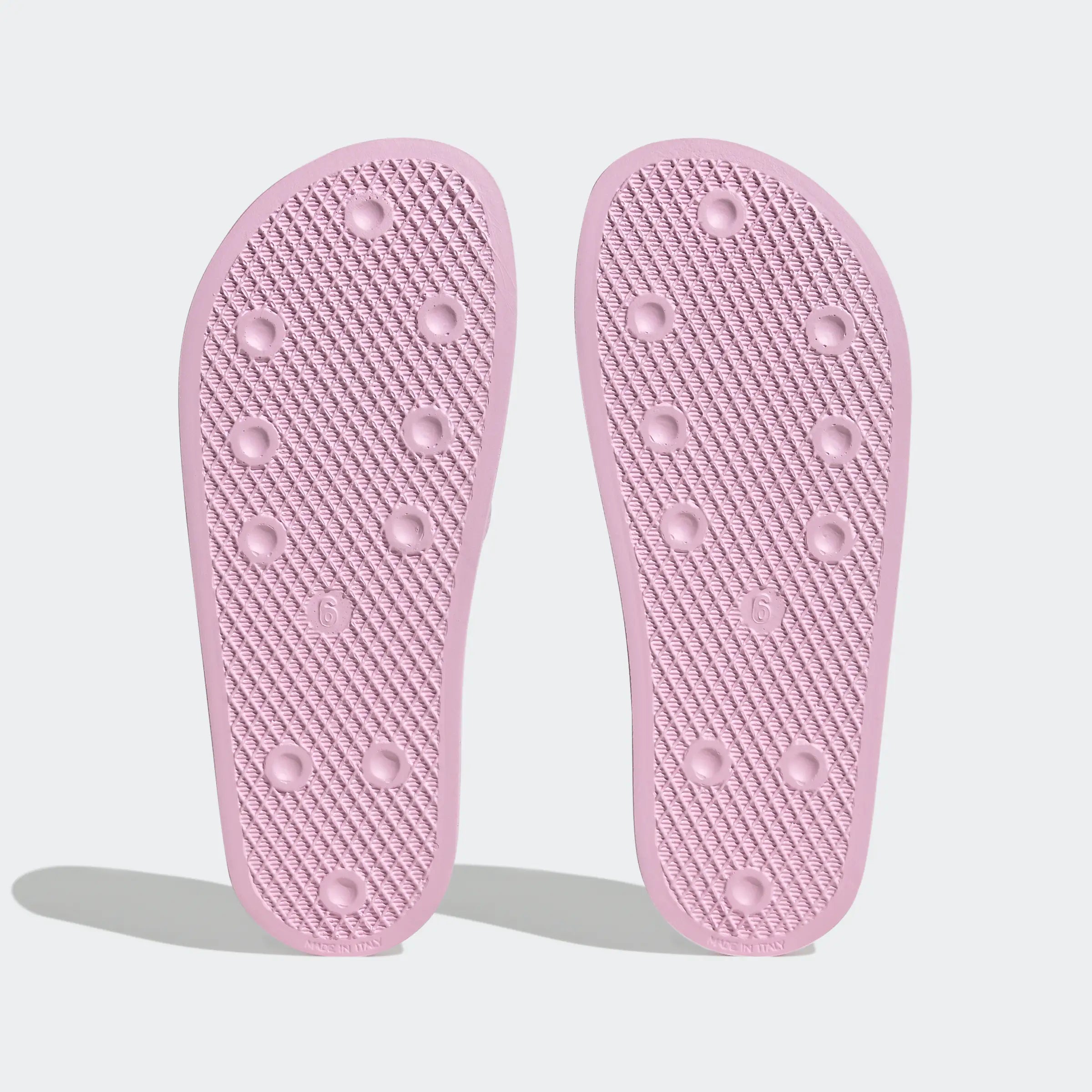 "Rosafarbene Adidas Adilette für Damen mit weißen Details. Klassische Badesandale mit breitem Riemen und weißem Adidas Logo. Bequemes, leichtes Material."