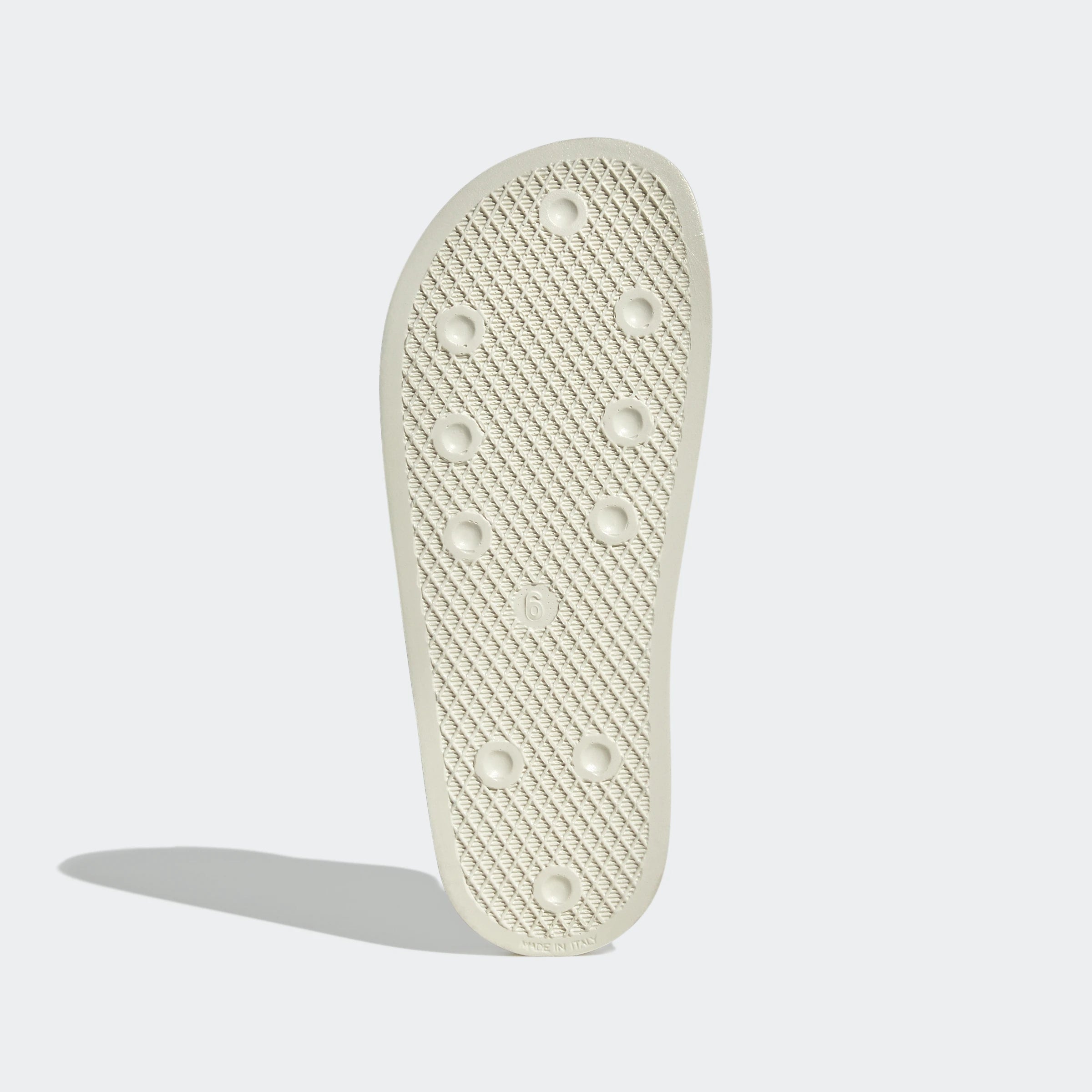 "Off-weiße Adidas Adilette für Damen. Klassische Badesandale mit breitem Riemen und Adidas Logo in derselben Farbe. Bequemes, leichtes Material."