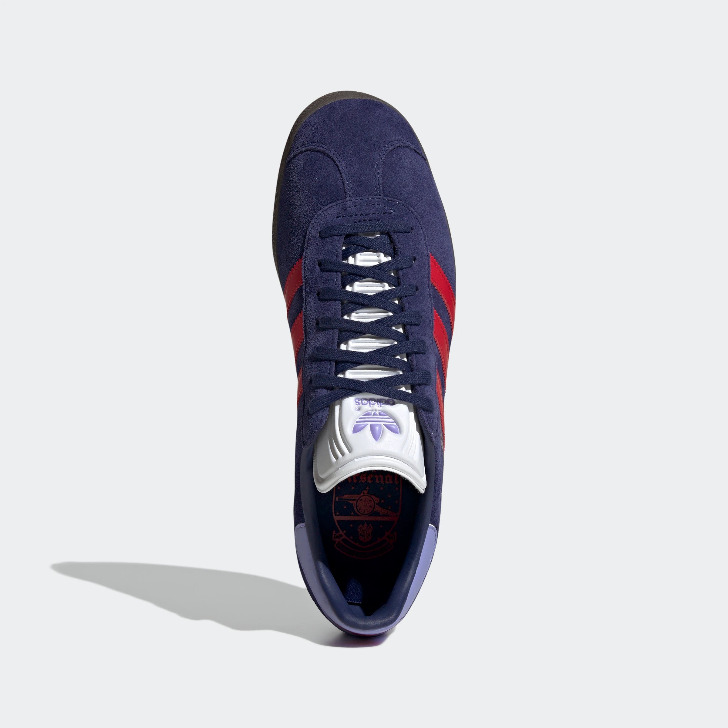 “Dunkelblaue Adidas Gazelle Rekive 'Arsenal FC' Sneaker mit roten und gummi-braunen Akzenten. Wildleder-Obermaterial, Leder-Overlays, goldene "Gazelle"- und "Arsenal"-Schriftzüge, 3-Streifen-Design, Schnürverschluss, Gummi-Außensohle. Fußball-inspirierter Retro-Look.“