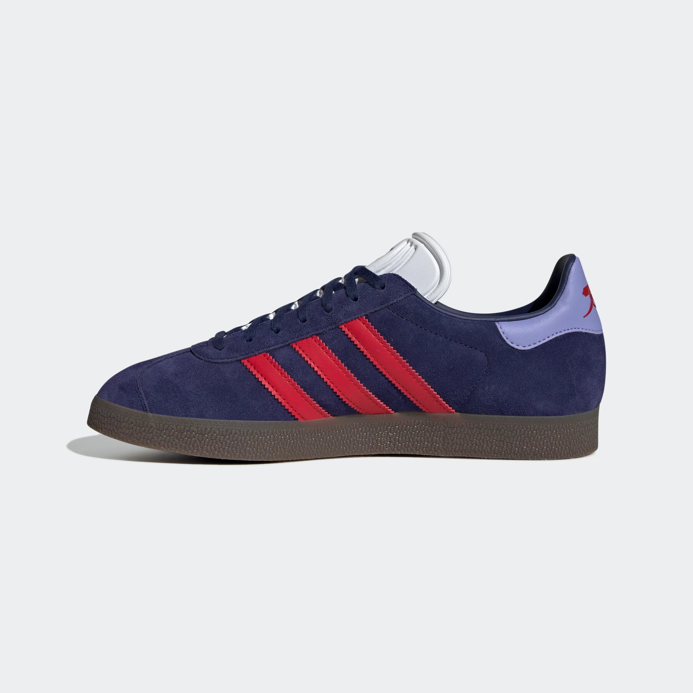 “Dunkelblaue Adidas Gazelle Rekive 'Arsenal FC' Sneaker mit roten und gummi-braunen Akzenten. Wildleder-Obermaterial, Leder-Overlays, goldene "Gazelle"- und "Arsenal"-Schriftzüge, 3-Streifen-Design, Schnürverschluss, Gummi-Außensohle. Fußball-inspirierter Retro-Look.“