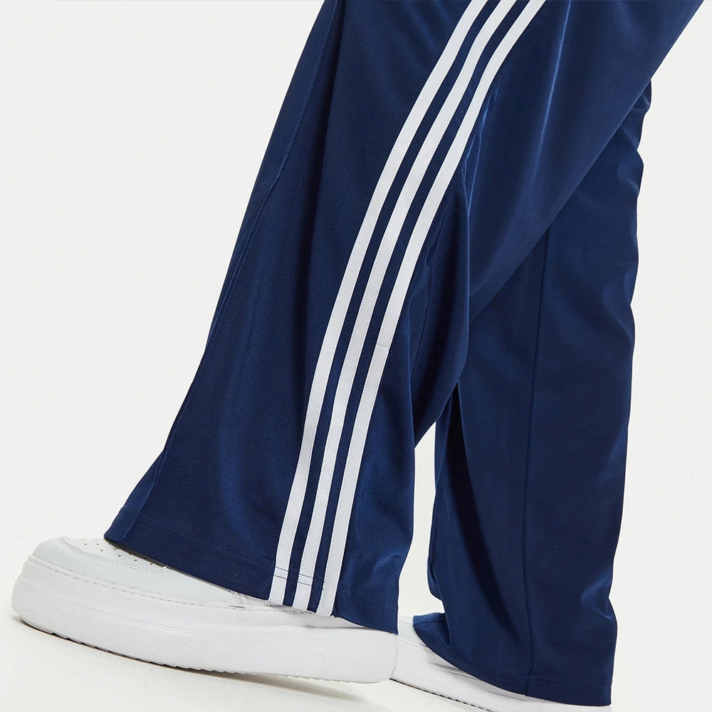 “Adidas Firebird Track Pants Loose Fit W in Dunkelblau. Lockere Hose aus glänzendem Trikotstoff, mit weißen 3-Streifen und gesticktem Logo.“