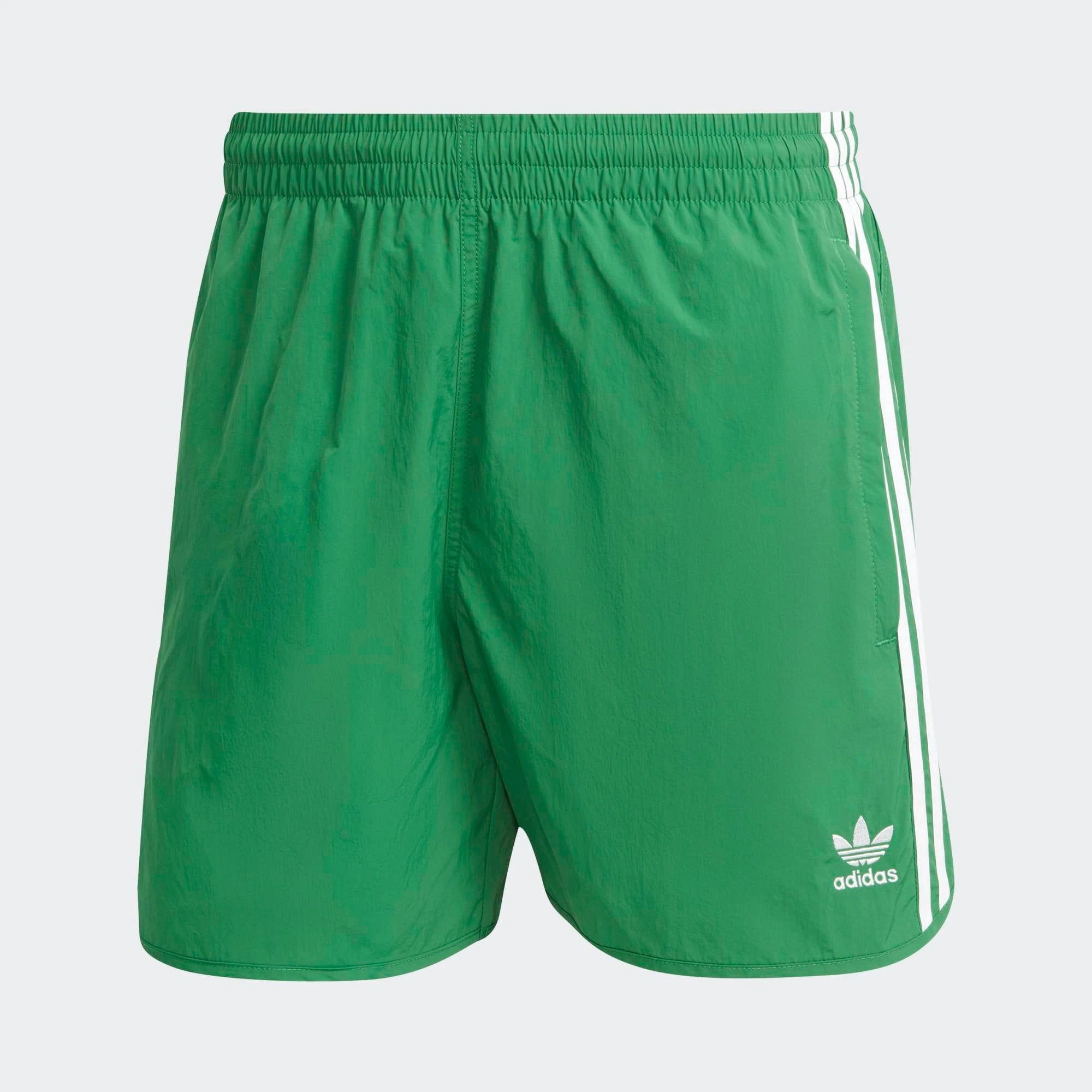 "Adidas Classics Sprinter Shorts. Kurze, grüne Shorts aus recyceltem Polyester, mit elastischem Bund, drei weißen Seitenstreifen und gesticktem Trefoil-Logo bei Stickabush Berlin."