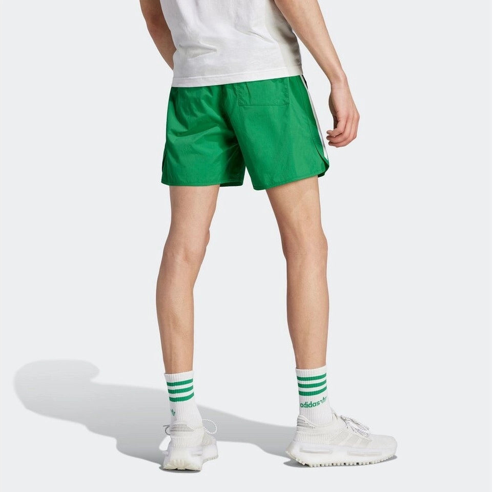 "Adidas Classics Sprinter Shorts. Kurze, grüne Shorts aus recyceltem Polyester, mit elastischem Bund, drei weißen Seitenstreifen und gesticktem Trefoil-Logo bei Stickabush Berlin."