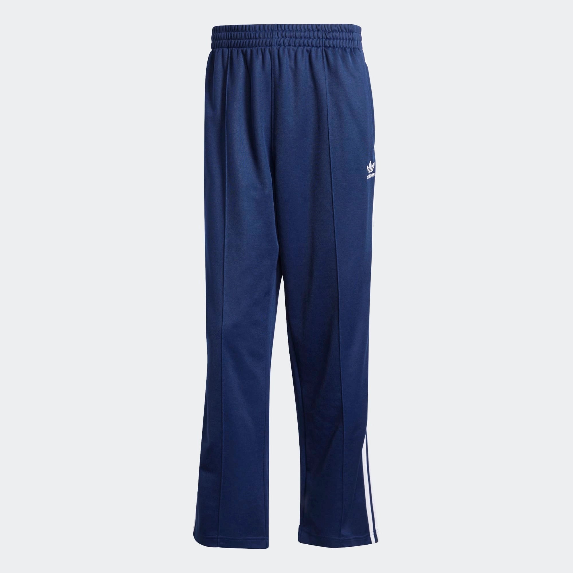 "Dunkelblaue Adidas Originals Baggy Fit Firebird Trainingshose mit weißen Streifen und weitem Beinverlauf bei Stickabush Berlin.“