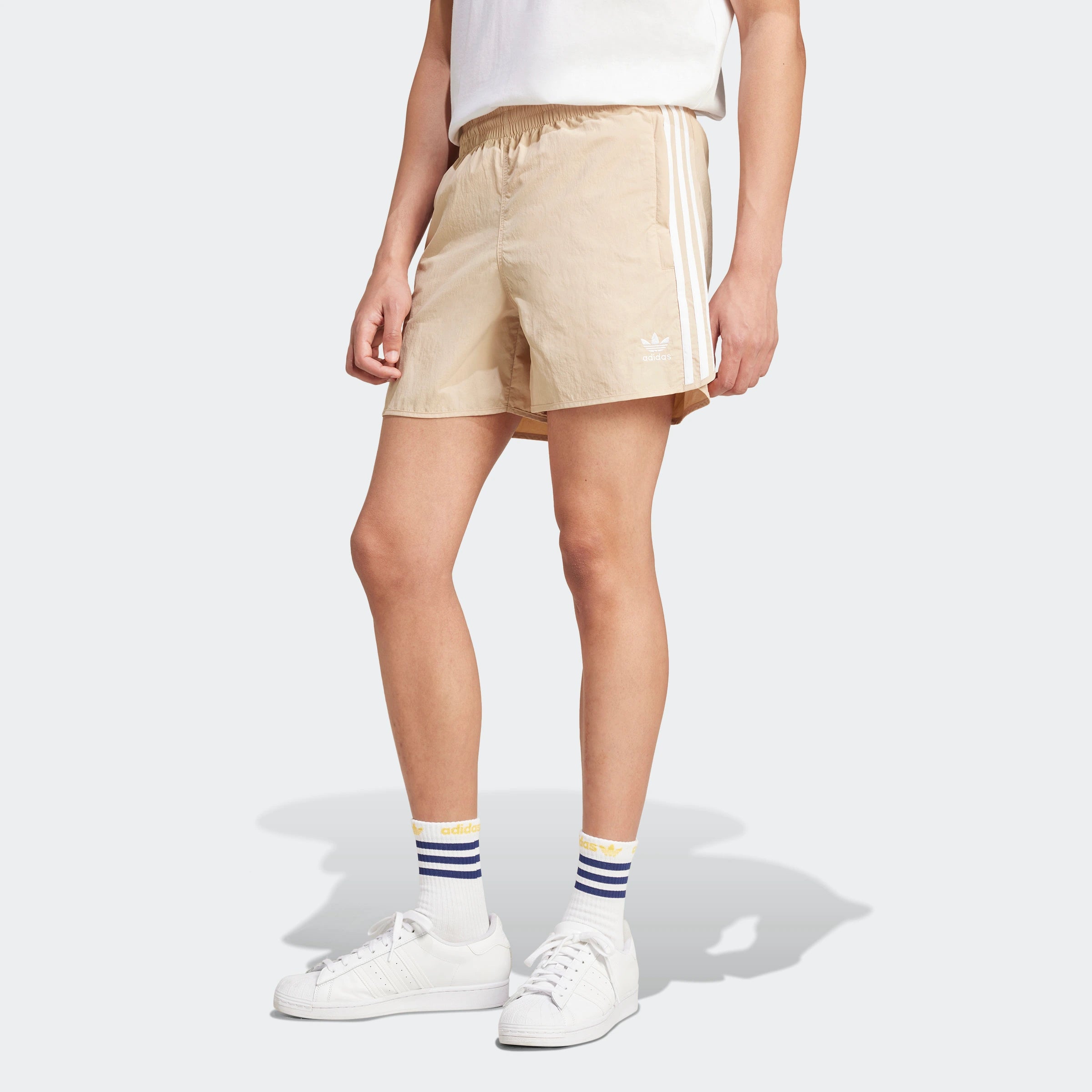 “Beige Adidas Classics Sprinter Shorts. Schlichtes Design, leichtes Material, seitliche 3 Streifen in Weiß, elastischer Bund mit Kordelzug.“