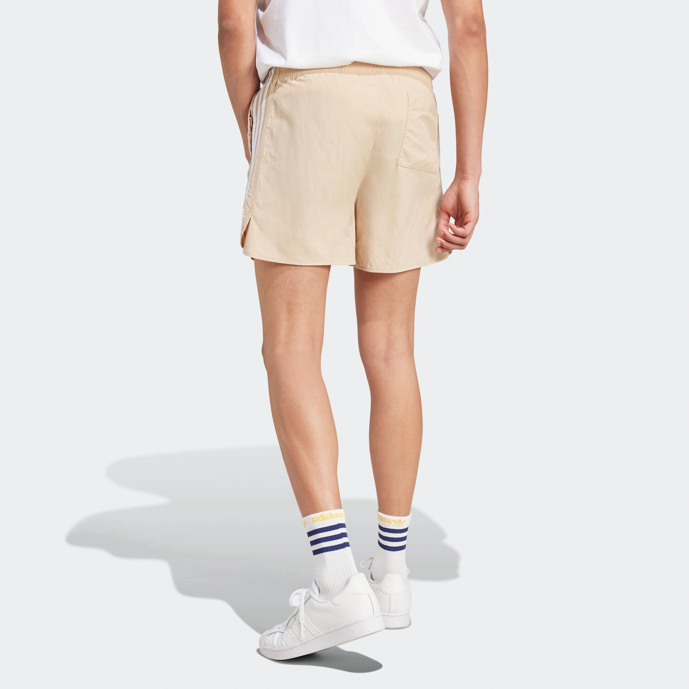 “Beige Adidas Classics Sprinter Shorts. Schlichtes Design, leichtes Material, seitliche 3 Streifen in Weiß, elastischer Bund mit Kordelzug.“