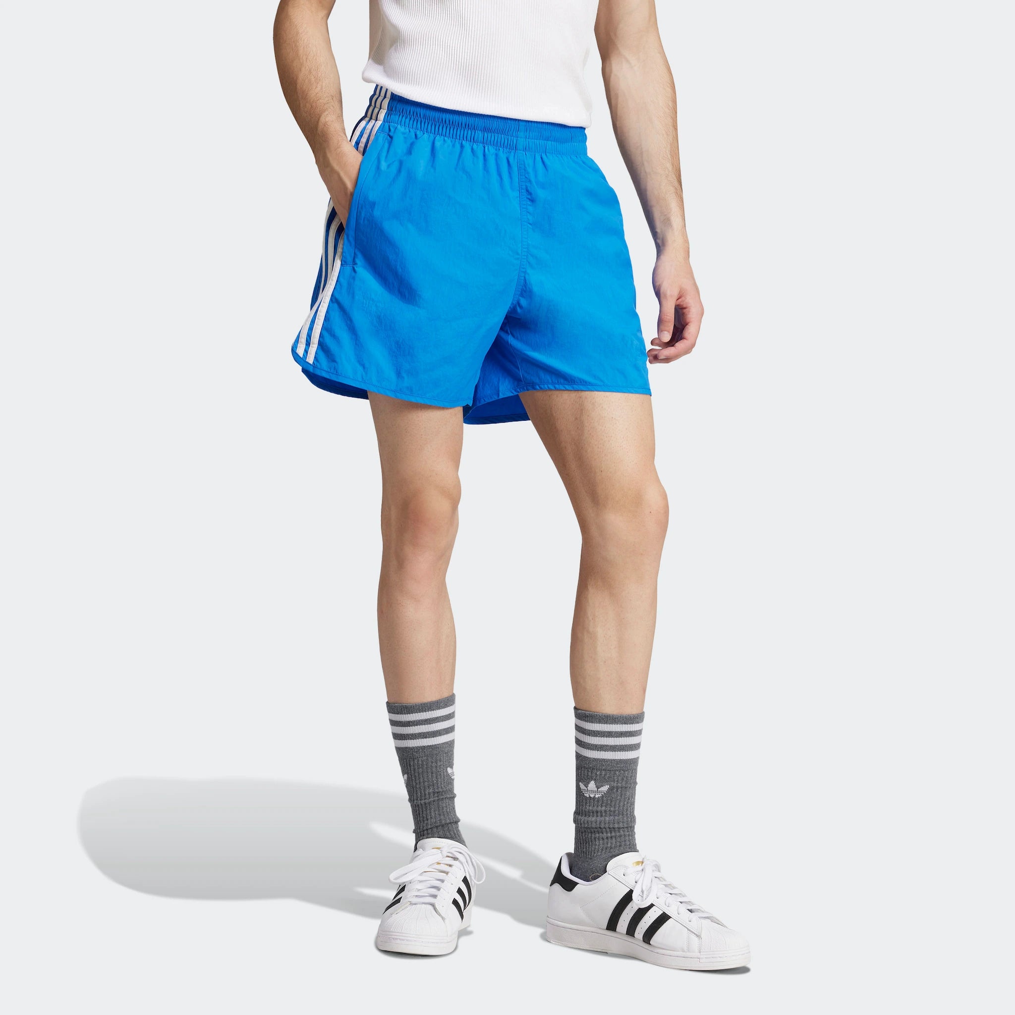 "Blaue Adidas Sprinter Shorts mit weißen seitlichen Streifen. Kurze, sportliche Hose mit elastischem Bund und kleinem Adidas Logo am Bein."
