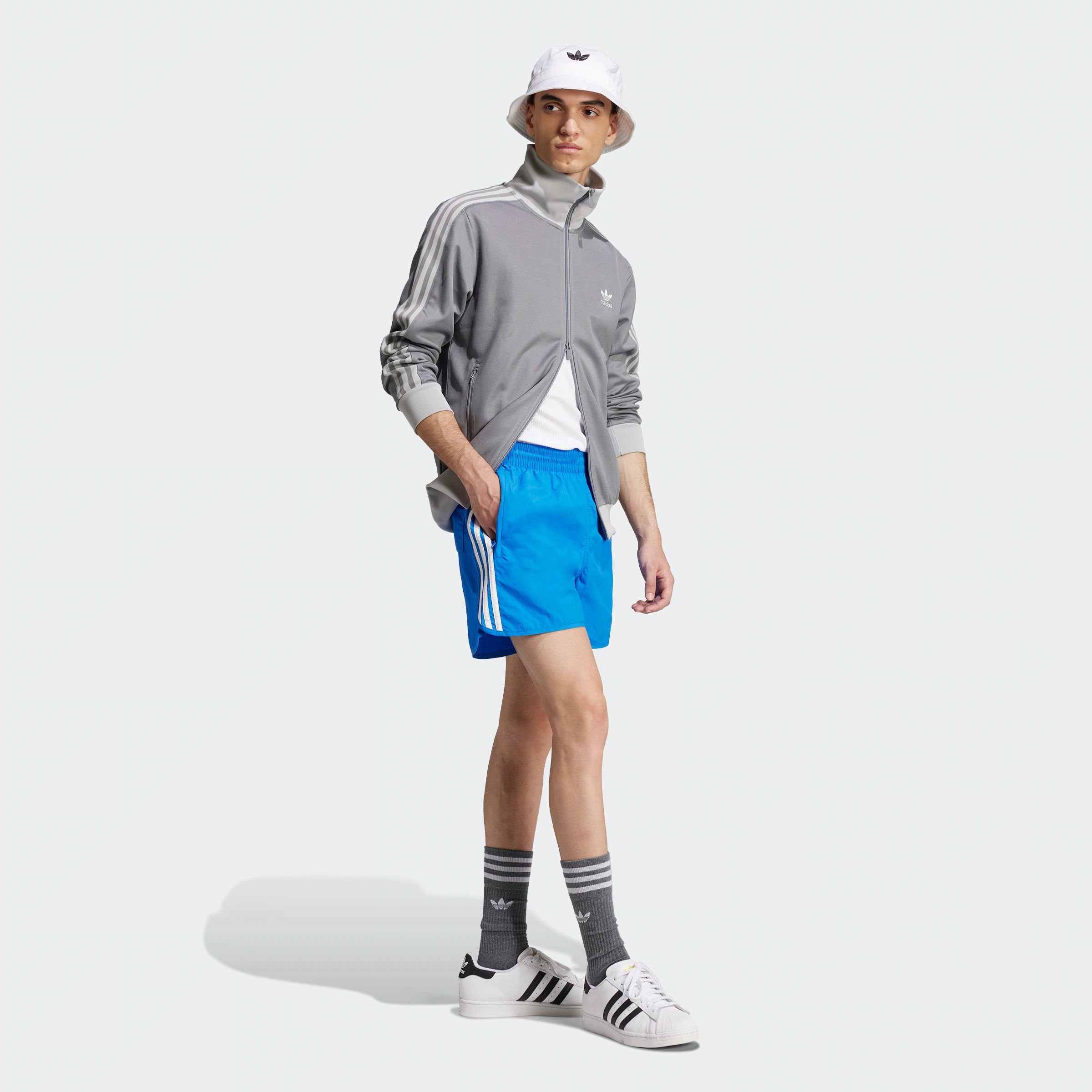 "Blaue Adidas Sprinter Shorts mit weißen seitlichen Streifen. Kurze, sportliche Hose mit elastischem Bund und kleinem Adidas Logo am Bein."