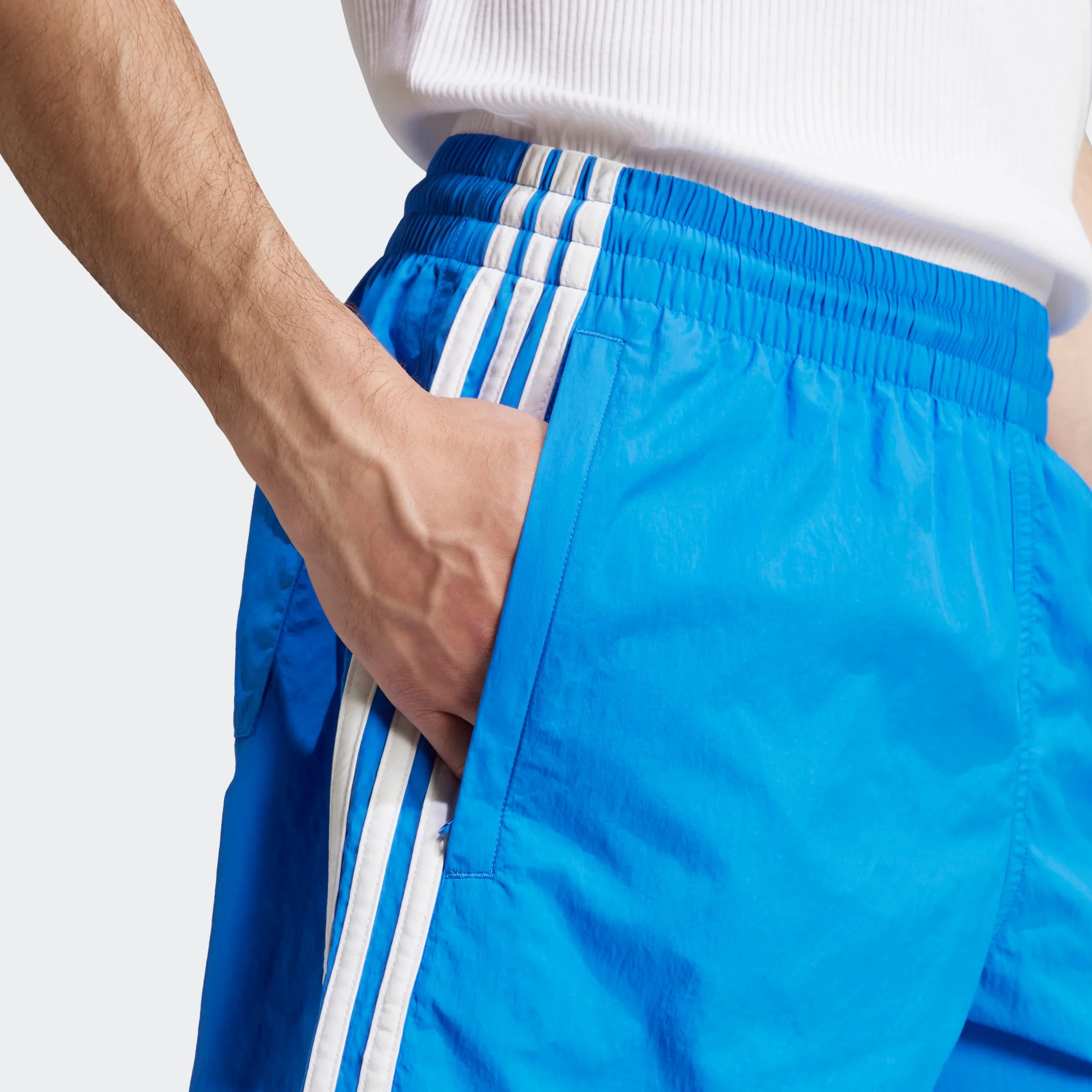 "Blaue Adidas Sprinter Shorts mit weißen seitlichen Streifen. Kurze, sportliche Hose mit elastischem Bund und kleinem Adidas Logo am Bein."