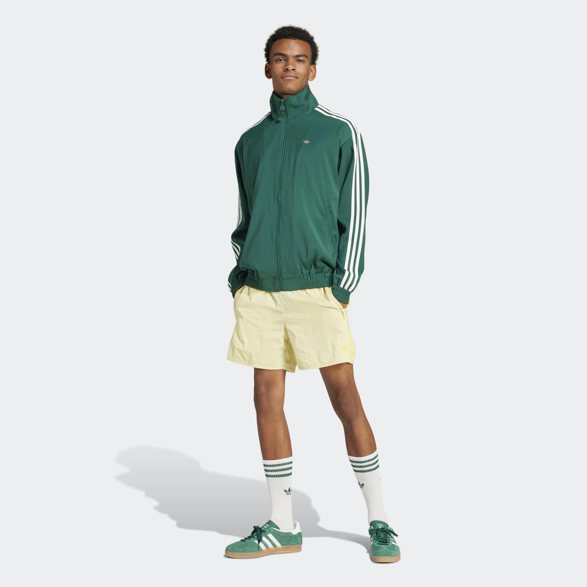 Adidas Classics Sprinter Shorts in einem hellen Gelb und mit gelben 3-Streifen und Trefoil-Logo, aus leichtem Material, von vorne abgebildet.