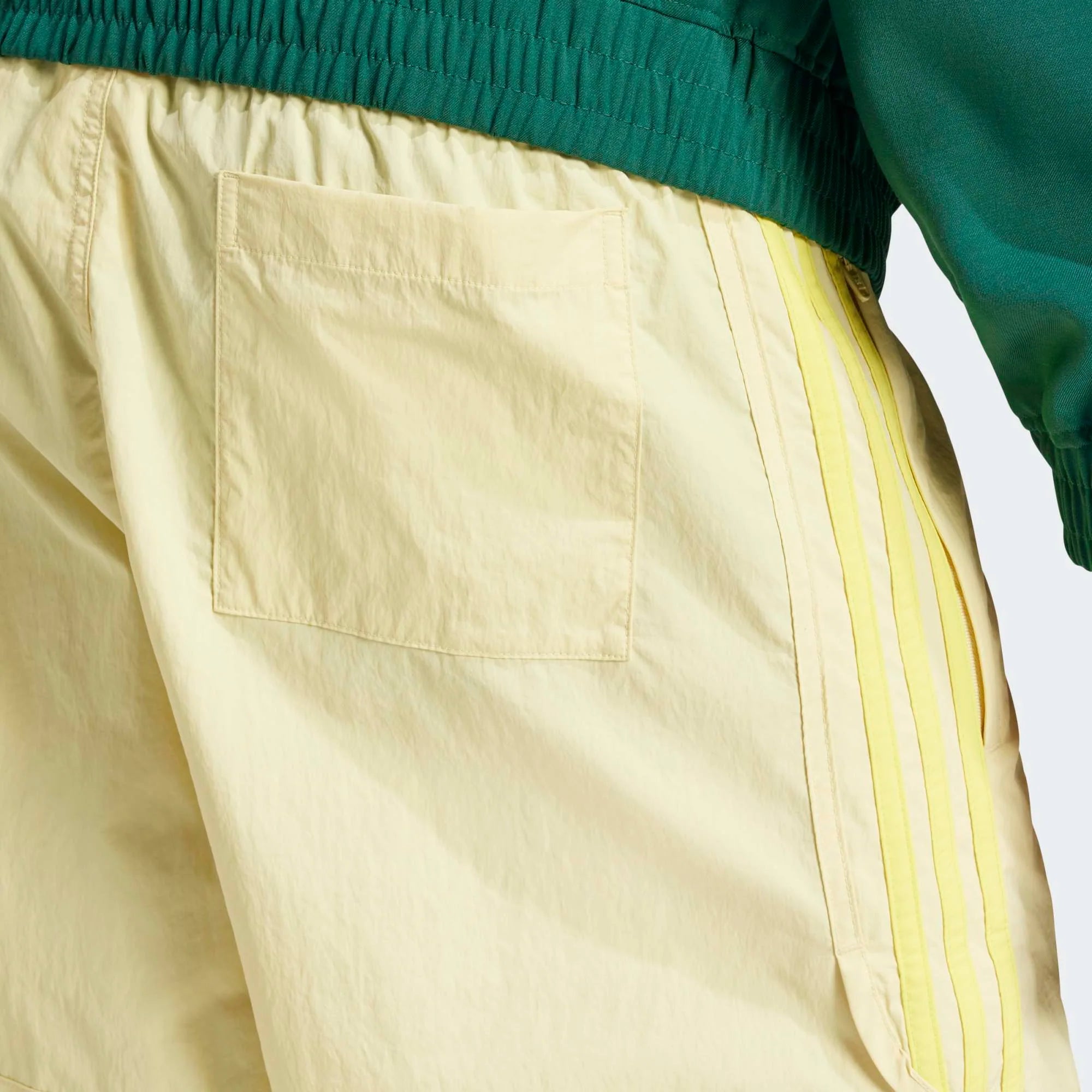 Adidas Classics Sprinter Shorts in einem hellen Gelb und mit gelben 3-Streifen und Trefoil-Logo, aus leichtem Material, von vorne abgebildet.