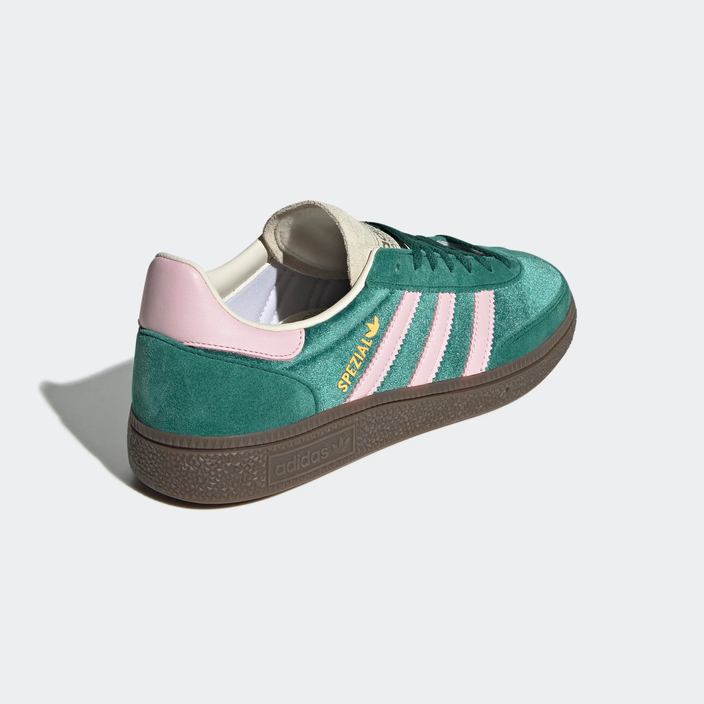 “Ein grüner Adidas-Sneaker, JI2648, mit rosa Streifen und dunkler Sohle. Der Schuh hat ein „Spezial“-Branding an der Seite.“
