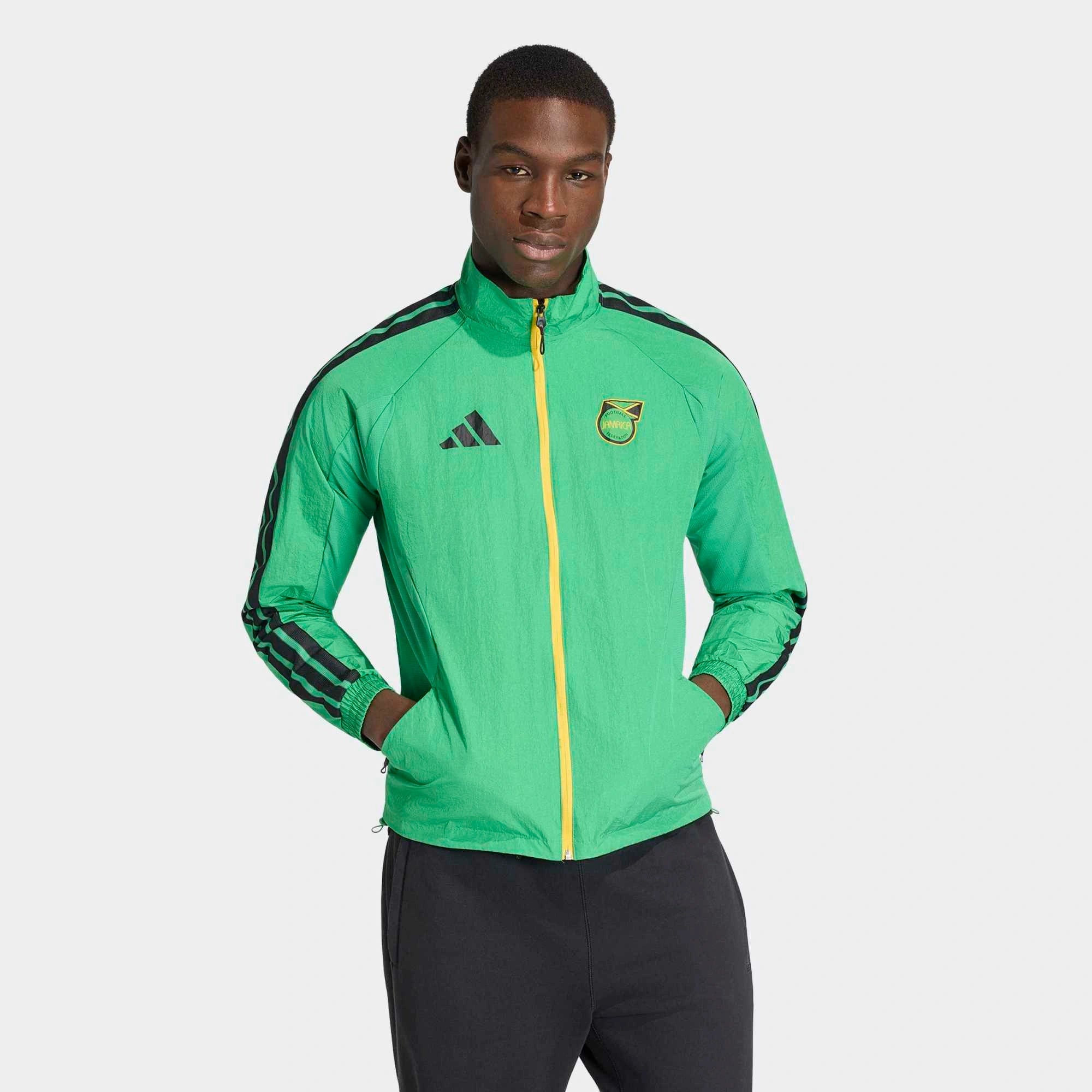 “Adidas Originals Jamaica Home Anthem Jacket in Vivid Green mit gelb-schwarzen Details und dem Logo des jamaikanischen Fußballverbandes bei Stickabush Berlin.“