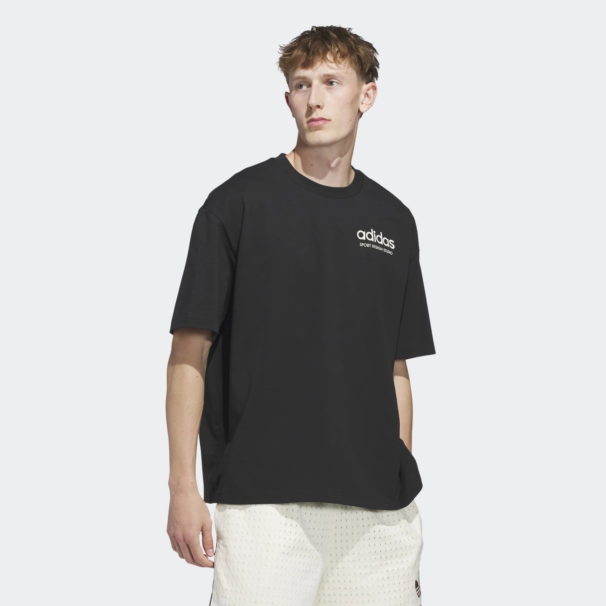 „Vorderansicht Model des adidas Originals Sport Design GFX Tee in Schwarz mit zentralem Retro-Sportgrafik-Print bei Stickabush Berlin.“