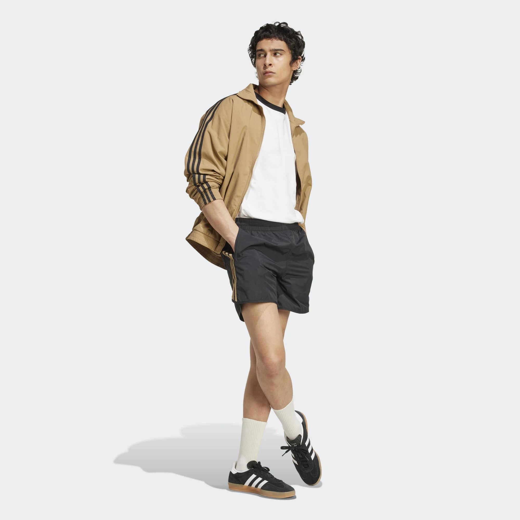 Adidas Classics Sprinter Shorts. Kurze, schwarze Shorts aus recyceltem Polyester, mit elastischem Bund, drei braunen Seitenstreifen und gesticktem Trefoil-Logo.