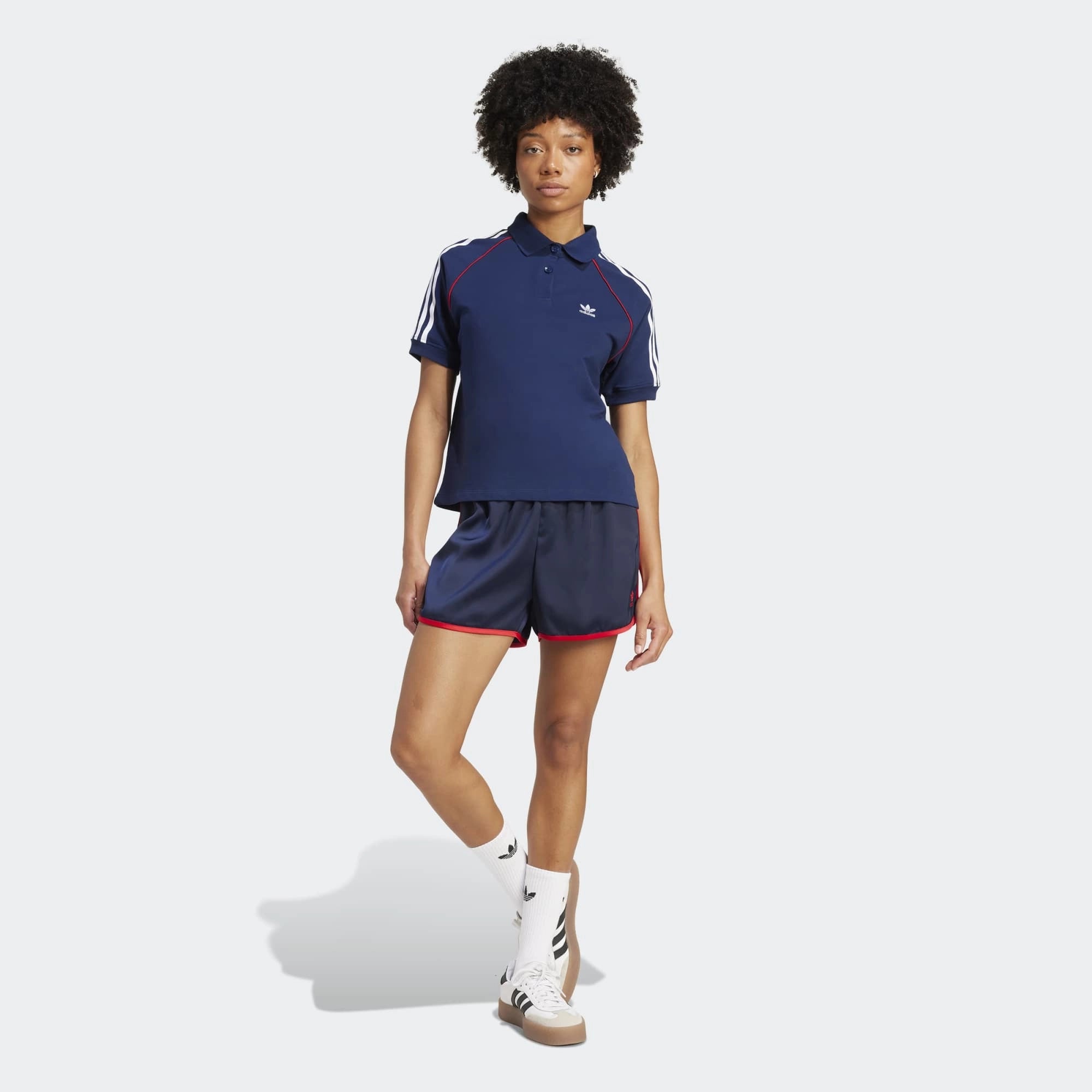 Adidas 3-Stripes Sprinter Shorts in Dunkelblau. Hergestellt aus recyceltem Polyester, mit leuchtend roten 3-Streifen an den Seiten.
