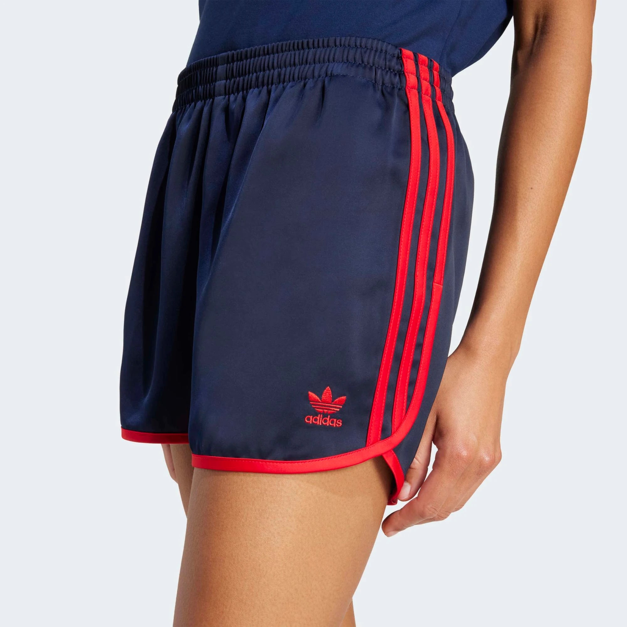 Adidas 3-Stripes Sprinter Shorts in Dunkelblau. Hergestellt aus recyceltem Polyester, mit leuchtend roten 3-Streifen an den Seiten.