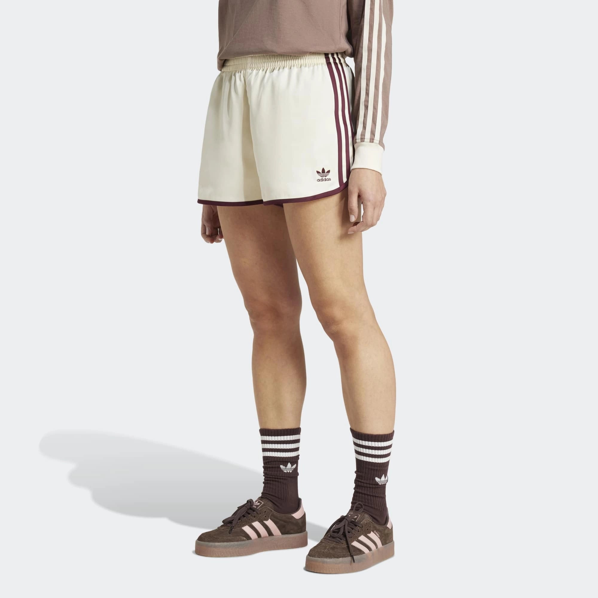 “adidas Originals 3-Stripes Sprinter Shorts W. Kurze, cremefarbene Damenshorts aus recyceltem Polyester, mit elastischem Bund, drei bordeaux-roten Seitenstreifen und gesticktem Trefoil-Logo bei Stickabush.“