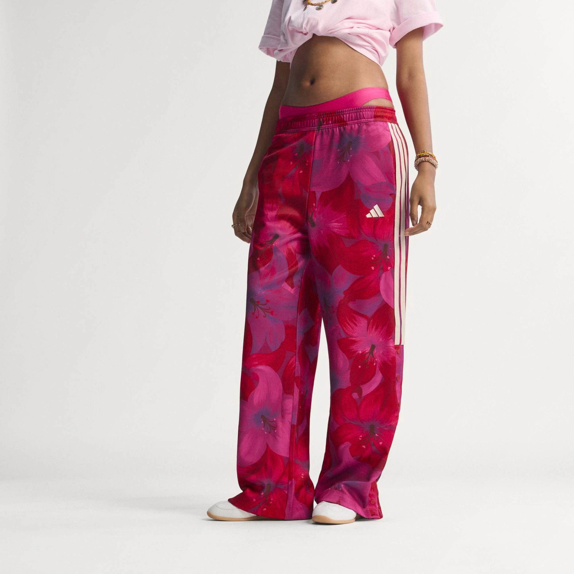 „Frauen adidas x Farm Rio Tiro Trainingshose in Bahia Magenta und Rot mit tropischem Blumenmuster an den Seiten und weißen 3-Streifen bei Stickabush Berlin.“