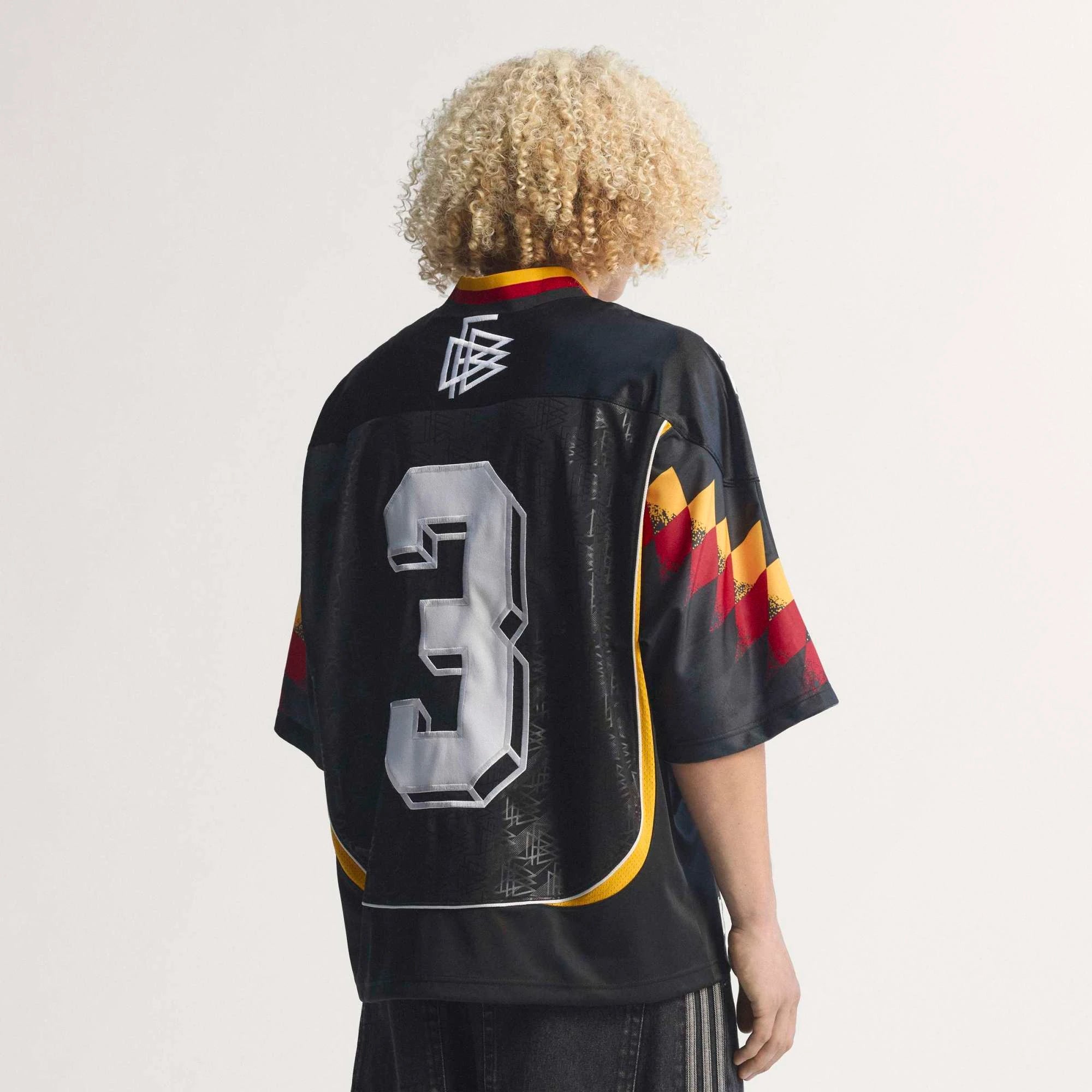 “Rückansicht Model des adidas Originals Bringback Remixed DFB Trikots KD5980 in Schwarz mit der großen weißen Nummer 3 und kleinen Nummern an den Schultern bei Stickabush.“