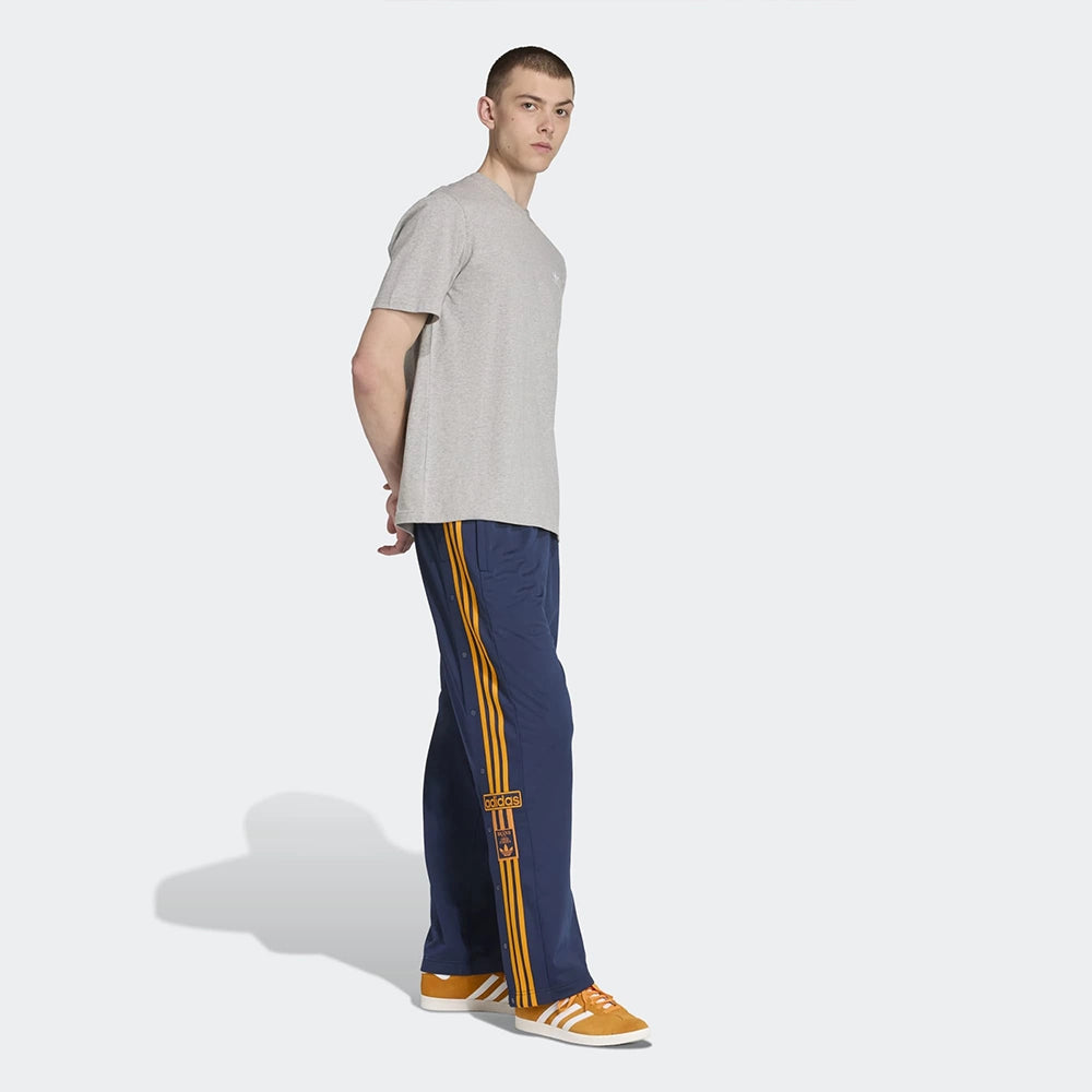 "Adidas Adibreak Track Pants in Blau/Orange, 100% recyceltes Trikot-Material, mit orangefarbenen 3-Streifen und seitlichen Druckknöpfen.“