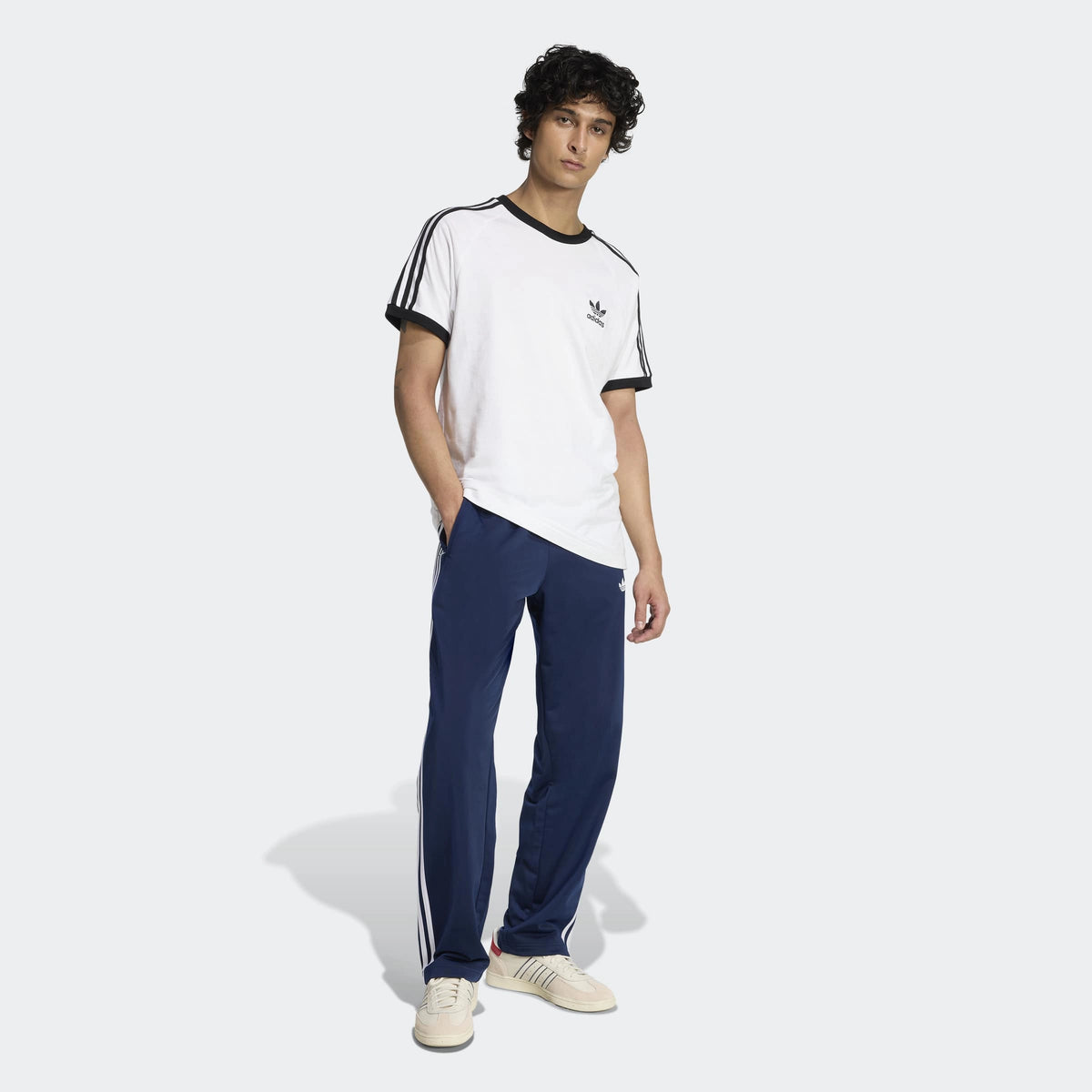 adidas Originals Firebird Track Pants in Night Indigo – Vorderansicht Outfit am Model der dunkelblauen Trainingshose im Retro-Look mit den ikonischen 3-Stripes.