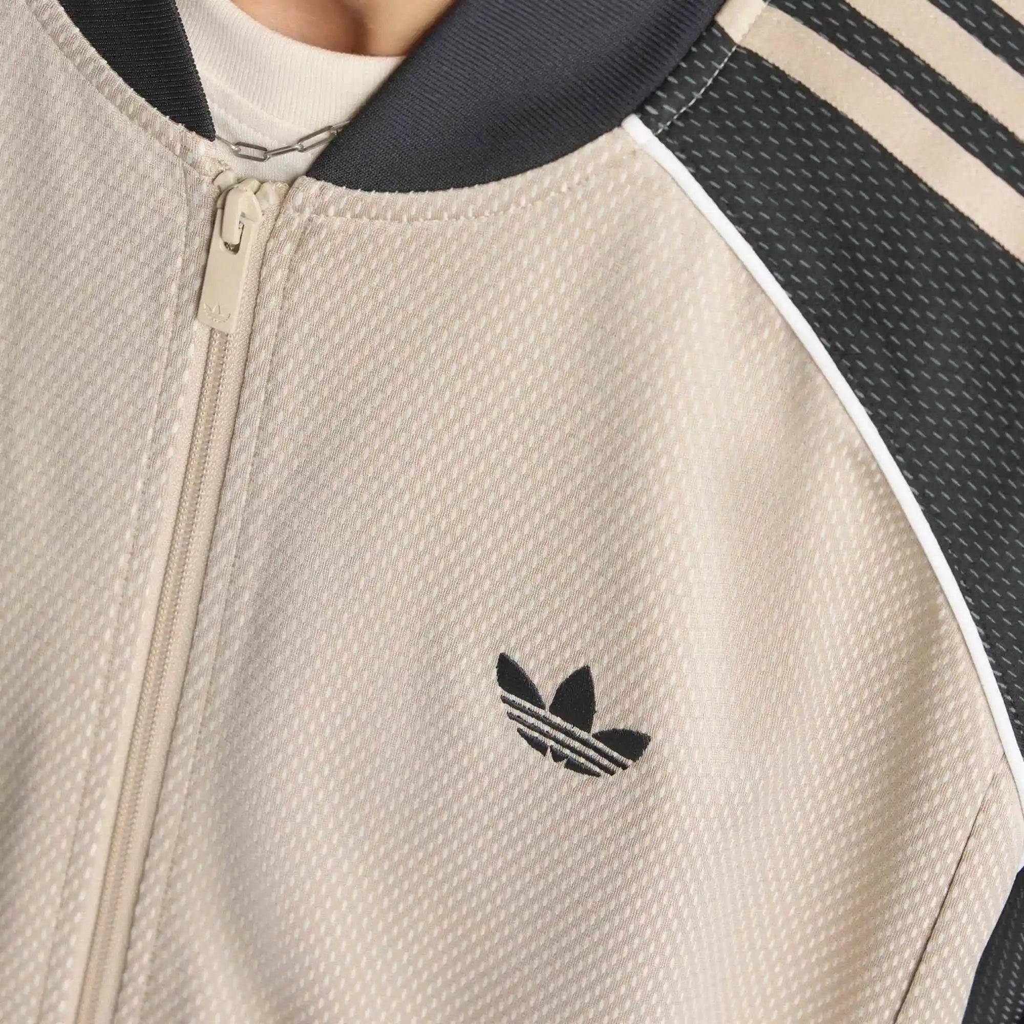 "adidas Originals SST Loose Mesh Track Top in Stone Khaki mit transparentem Mesh-Gewebe und weißen 3-Streifen auf den Ärmeln bei Stickabush Berlin.“