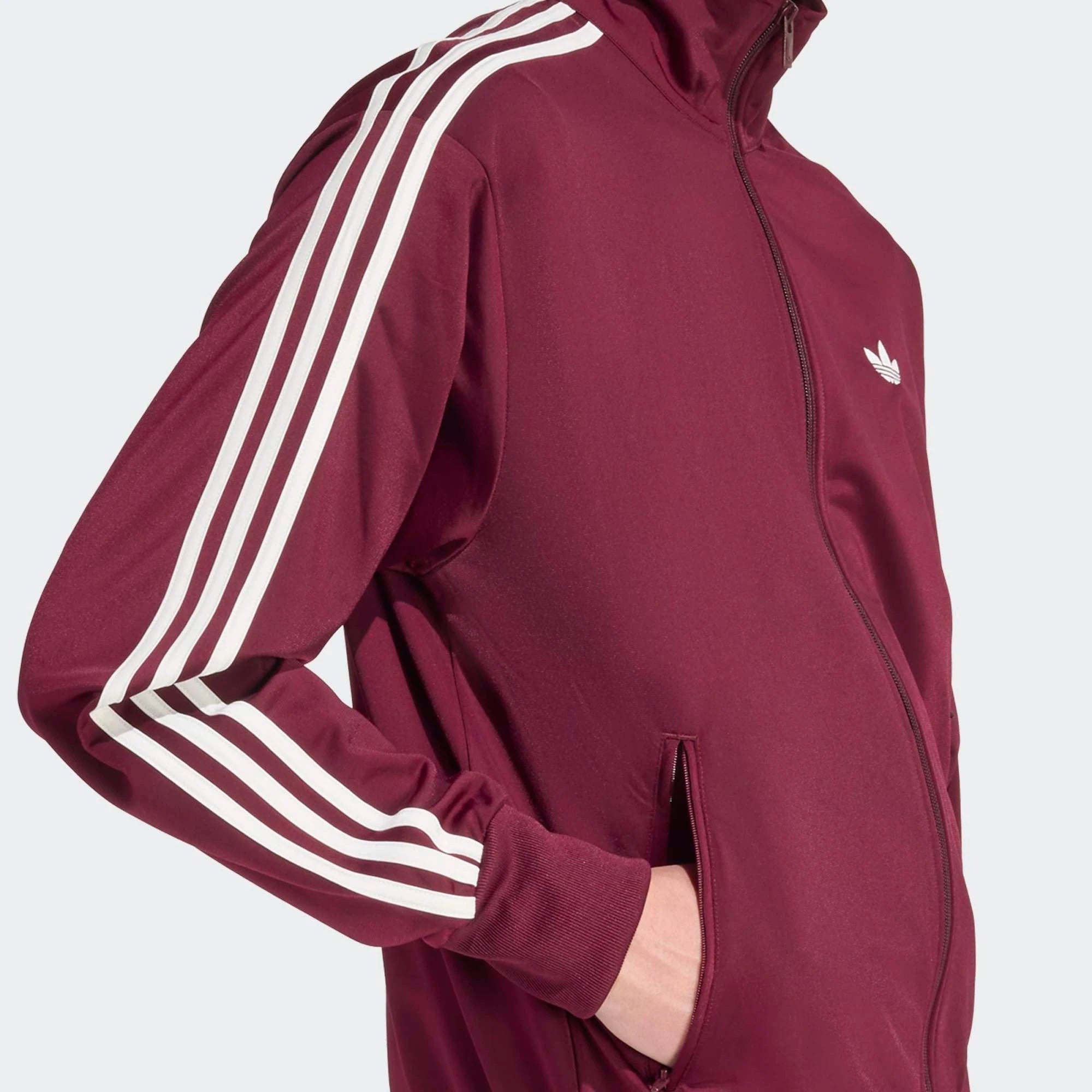 „Weinrote adidas Originals Firebird Trainingsjacke mit weißen 3-Streifen, Stehkragen und Trefoil-Logo in der Farbkombination Maroon / Off White bei Stickabush Berlin.“