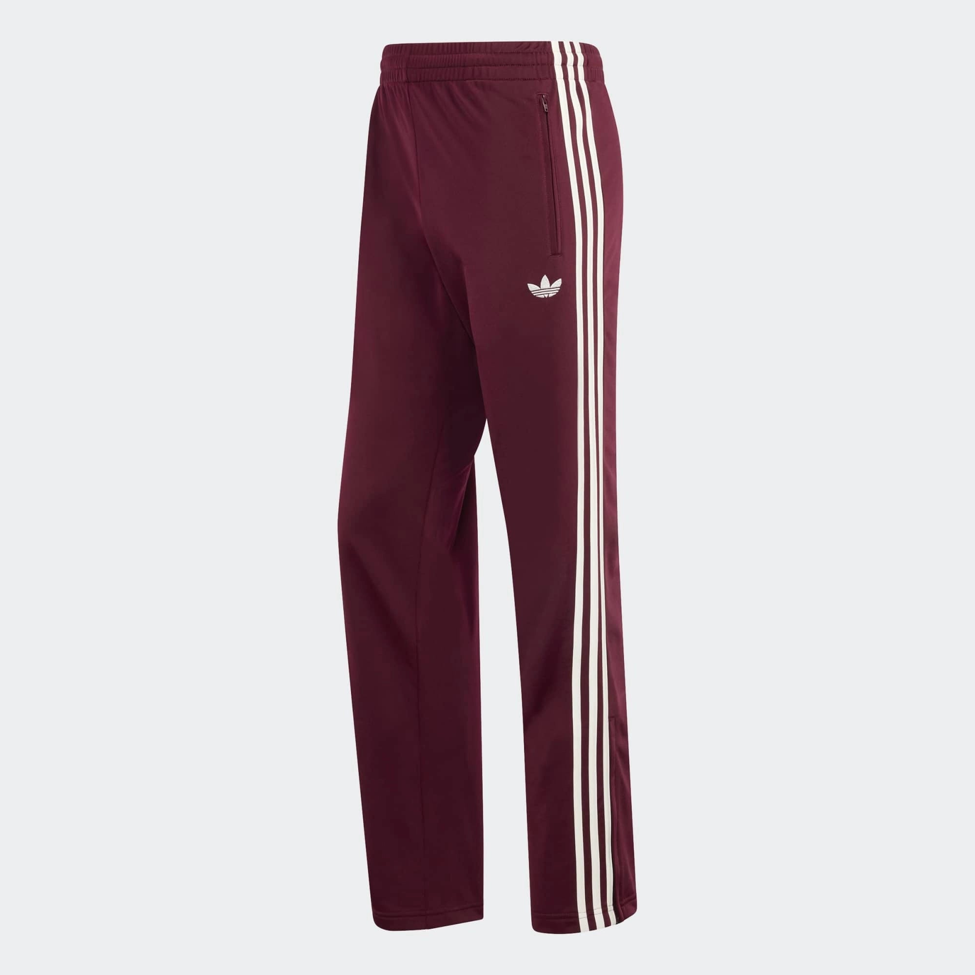 „Vorderansicht der Adidas Originals Firebird Track Pants in Maroon (Dunkelrot) mit cremeweißen 3-Streifen – Klassische Retro-Trainingshose bei Stickabush Berlin.“