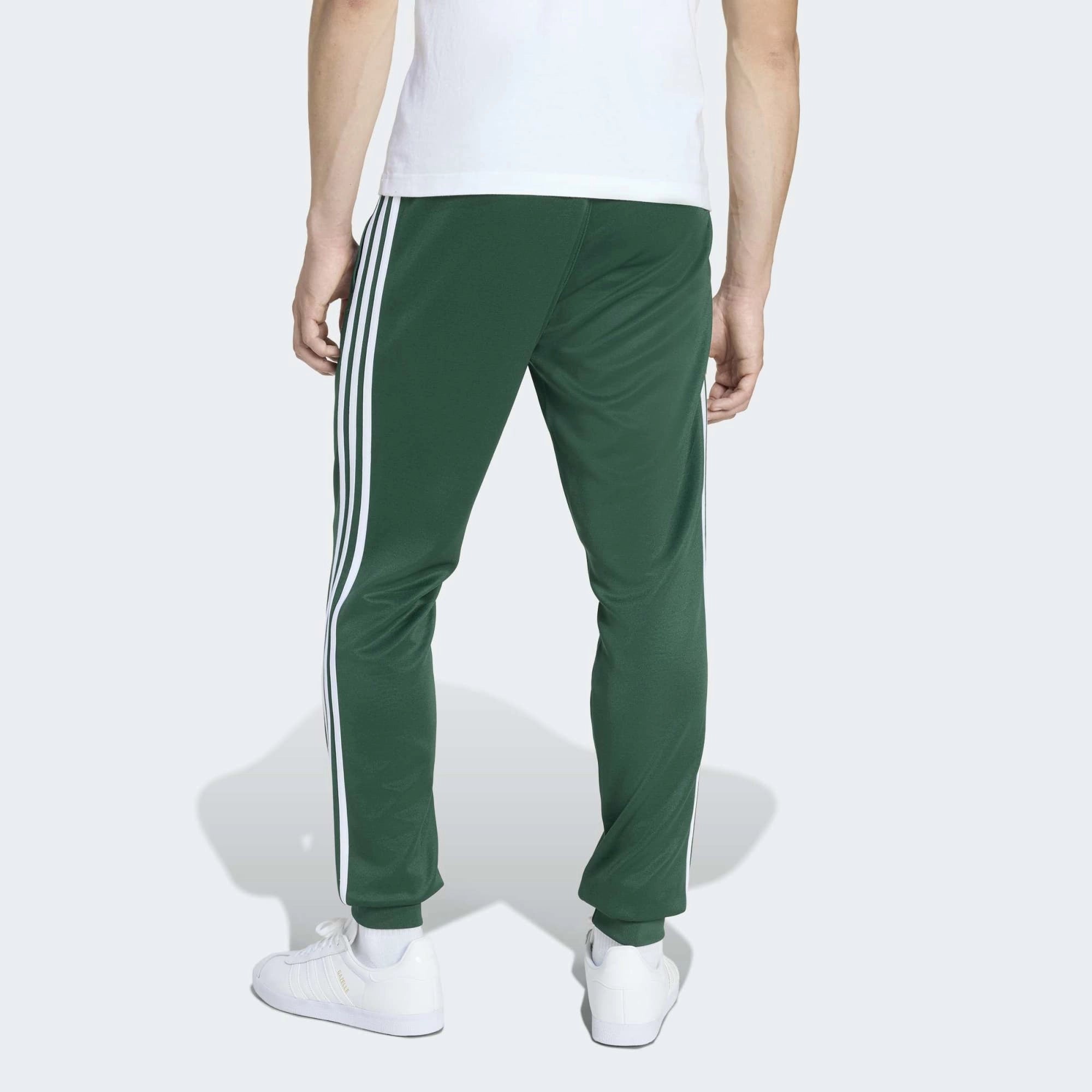 "adidas Originals SST Track Pants Herren in Collegiate Green Dunkelgrün, weißes Trefoil Logo, Slim Fit mit Rippbündchen bei Stickabush.“