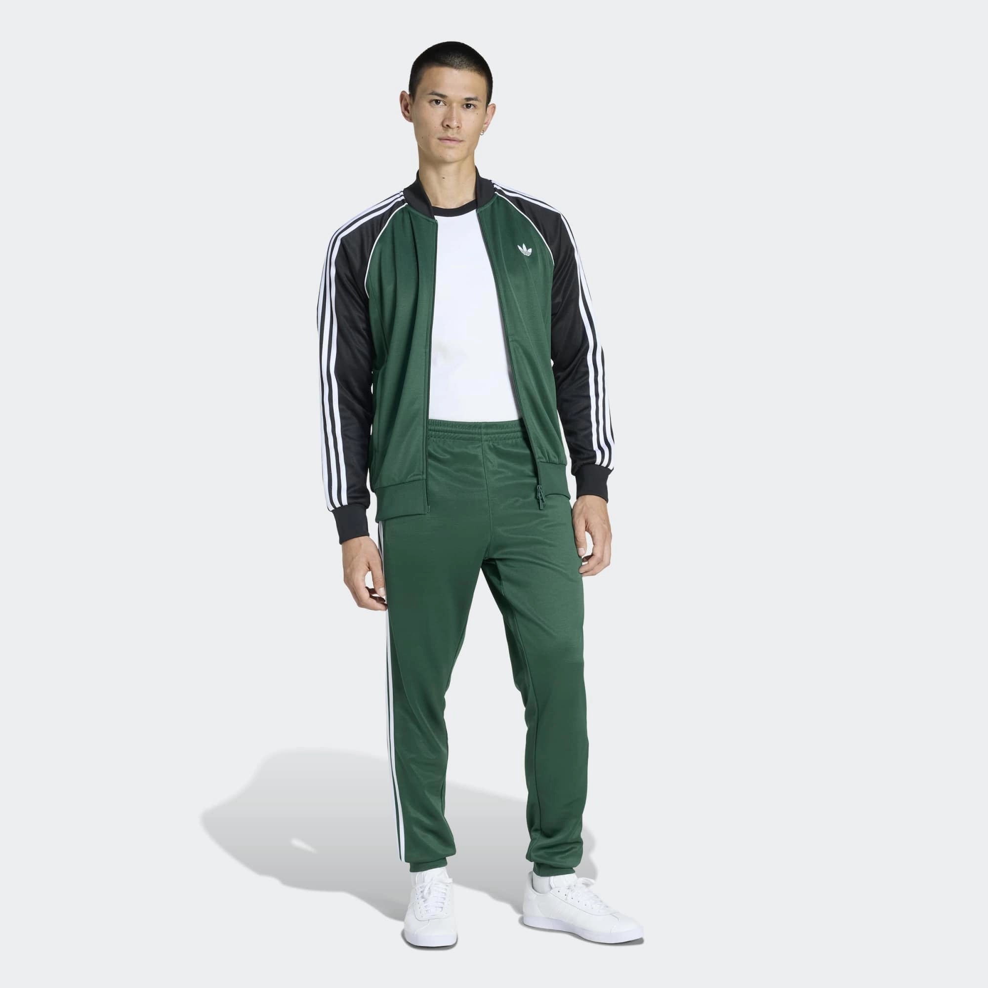 "adidas Originals SST Track Pants Herren in Collegiate Green Dunkelgrün, weißes Trefoil Logo, Slim Fit mit Rippbündchen bei Stickabush.“