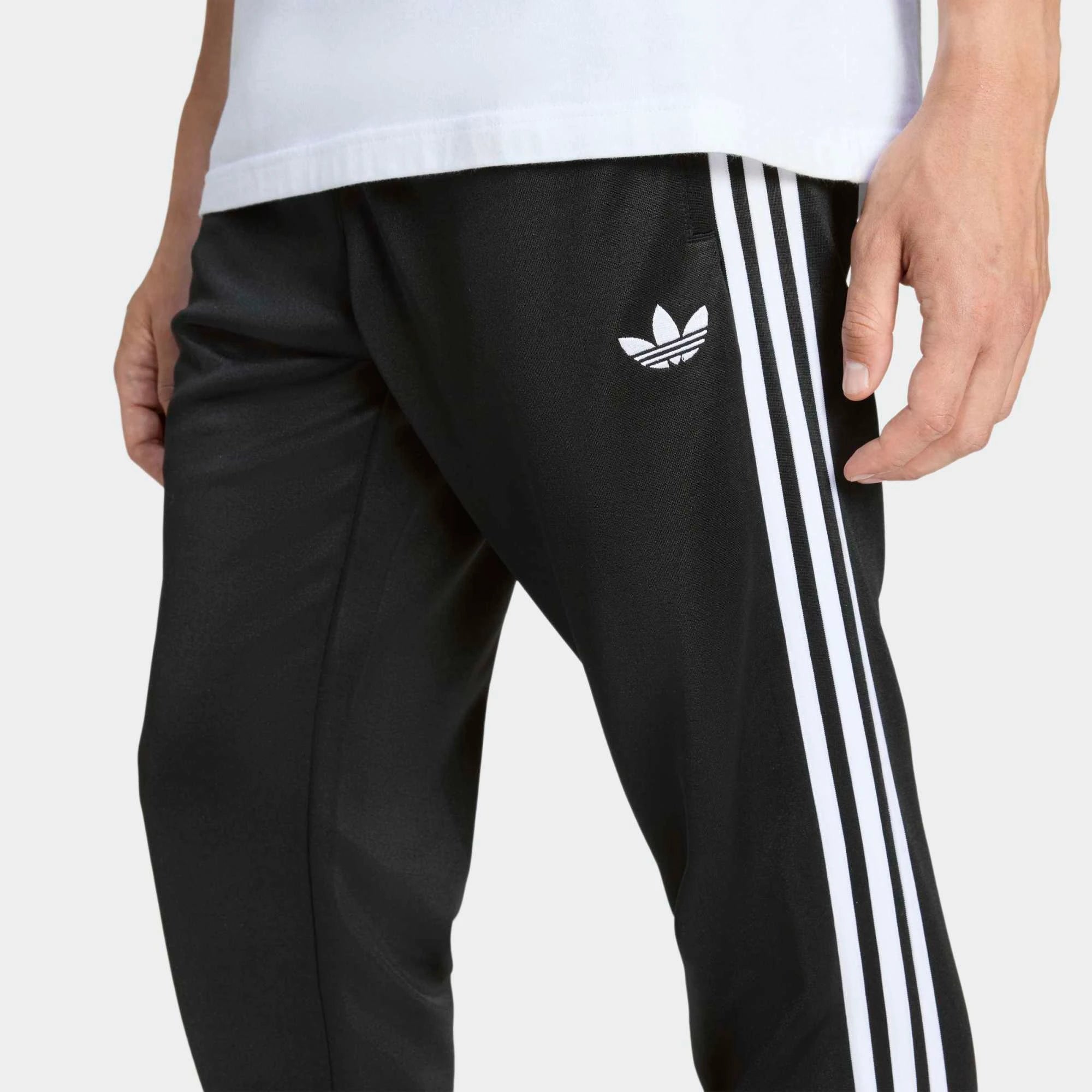 "Schwarze adidas Originals SST Trainingshose mit weißen 3-Streifen, Trefoil-Logo und schmal zulaufendem Bein bei Stickabush Berlin."