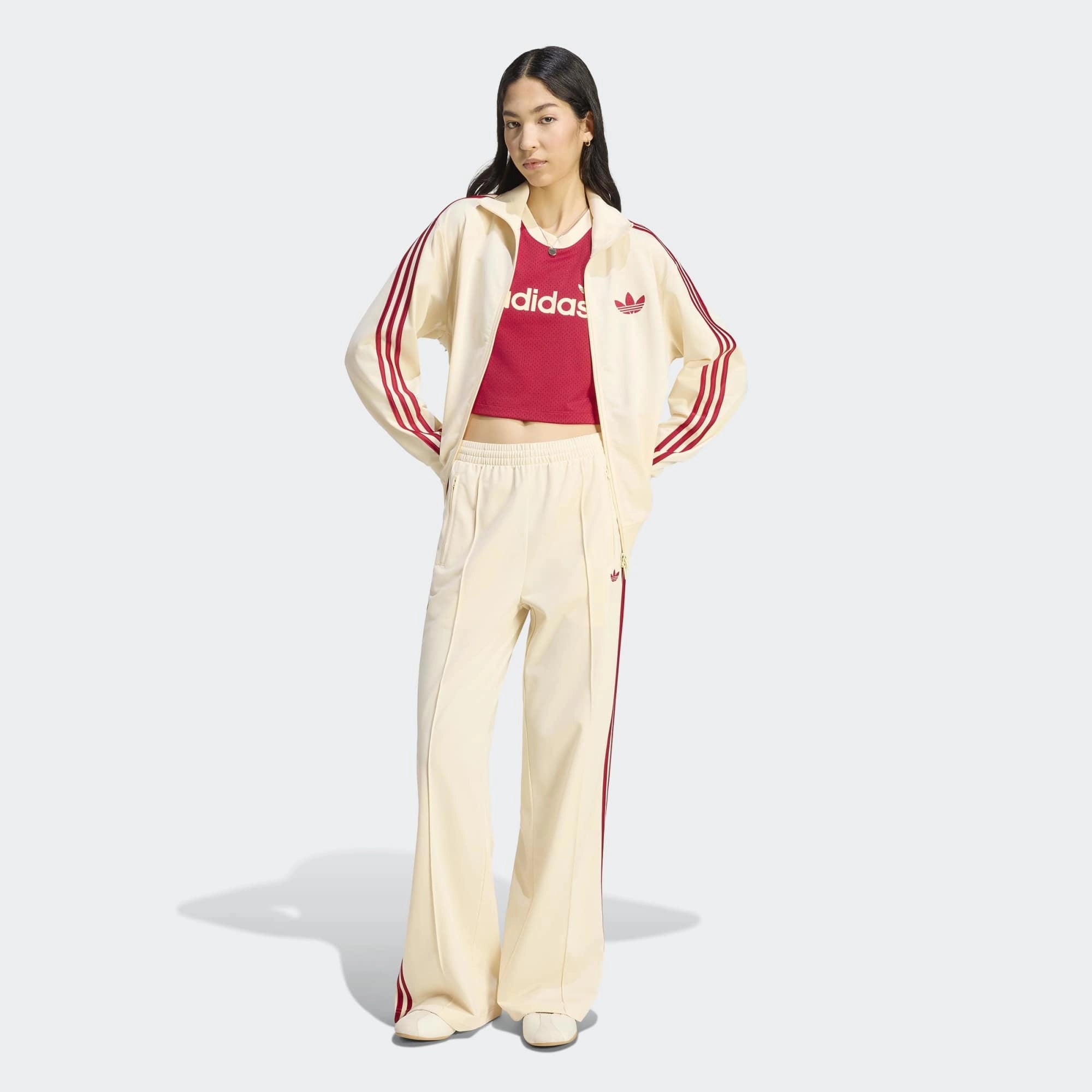 “adidas Originals Firebird Loose Damen Trainingshose in hellem Vanilla-Weiß mit roten drei Streifen und Trefoil-Logo bei Stickabush Berlin.“