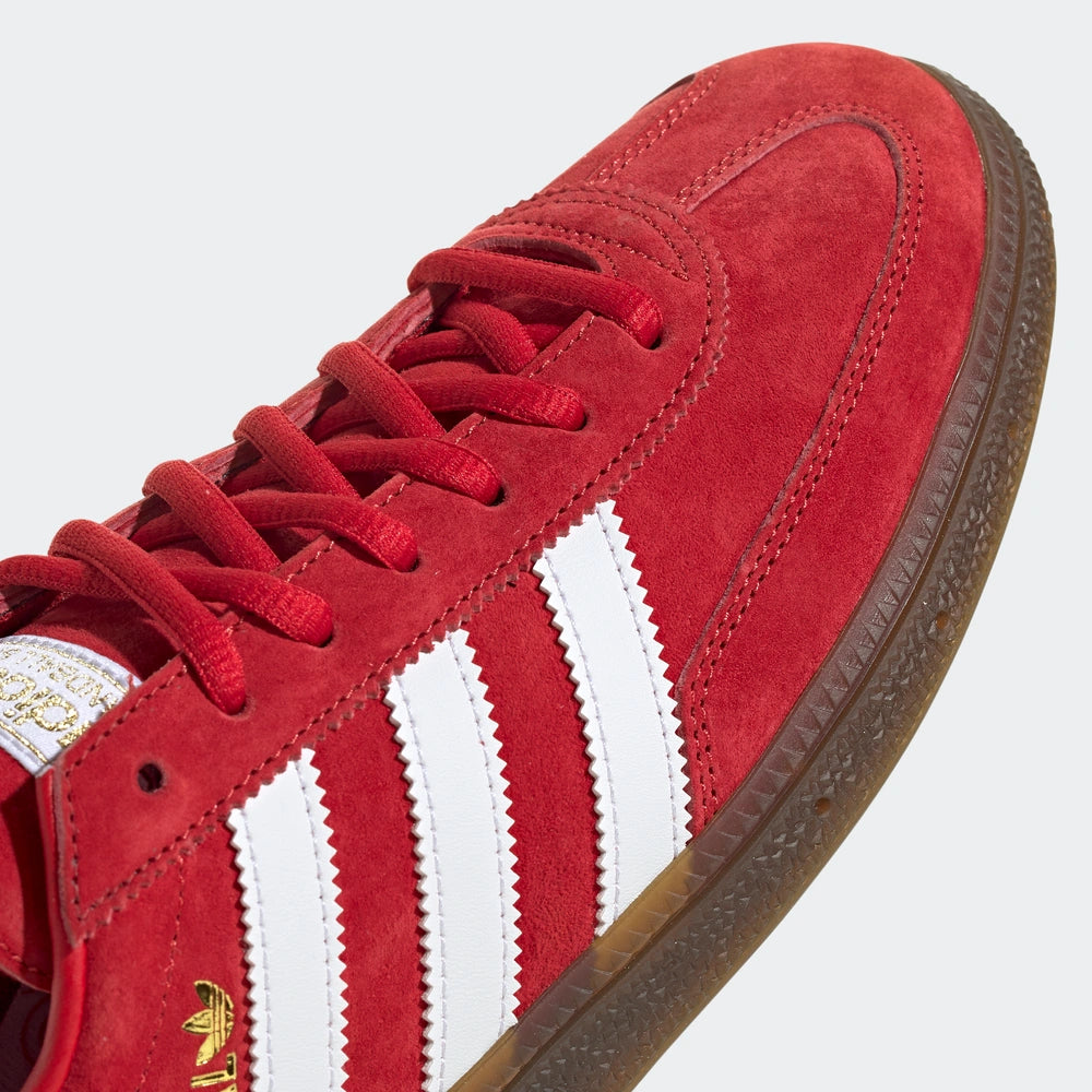 "Adidas Handball Spezial, Red/White (Rot/Weiß), Wildleder, klassischer Handballschuh mit weißen Streifen und goldener 'Spezial'-Aufschrift."