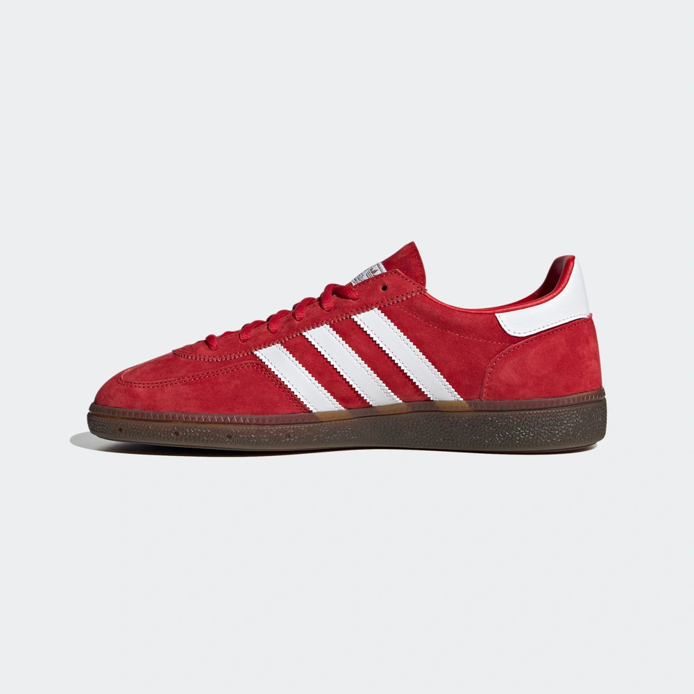 "Adidas Handball Spezial, Red/White (Rot/Weiß), Wildleder, klassischer Handballschuh mit weißen Streifen und goldener 'Spezial'-Aufschrift."