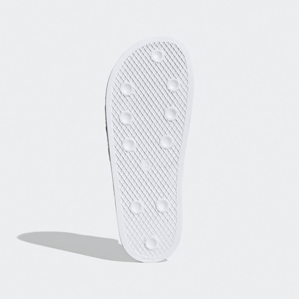 “Sohlenansicht der Adidas Originals Adilette in White / Black – Klassische Badeschlappen mit weißen 3-Streifen auf schwarzem Riemen und vorgeformtem Fußbett bei Stickabush Berlin.“