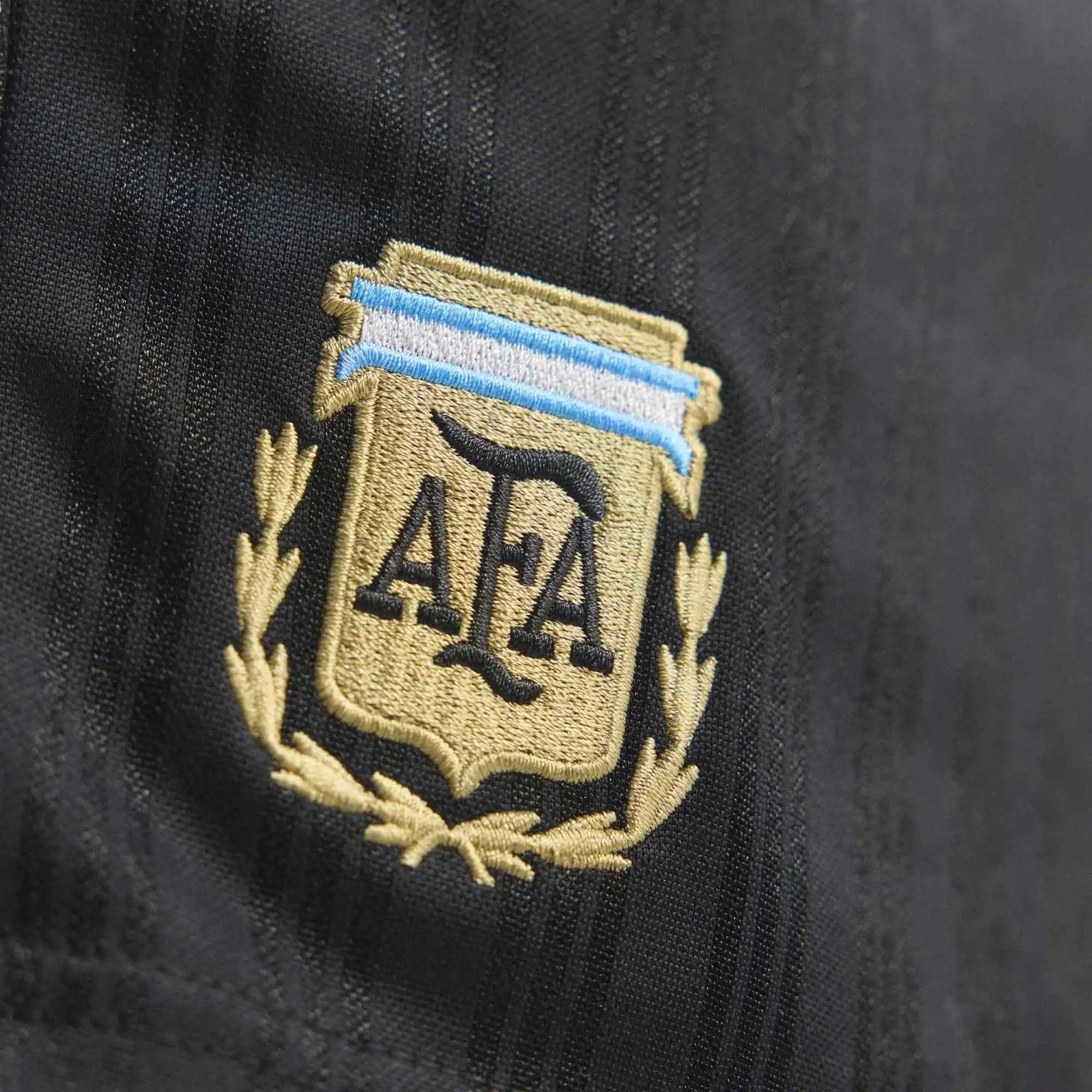 “Schwarze adidas Originals Argentinien OG Shorts mit weißen Streifen und gesticktem AFA-Verbandswappen bei Stickabush.“
