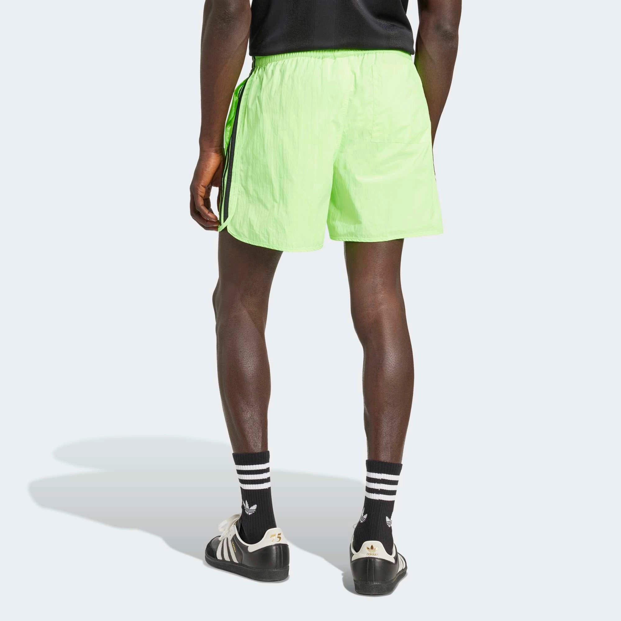 “Adidas Classics Sprinter Shorts in Signal Green – Kurze Retro-Sporthose mit schwarzen 3-Streifen, Trefoil-Logo und Reißverschlusstaschen bei Stickabush Berlin.“