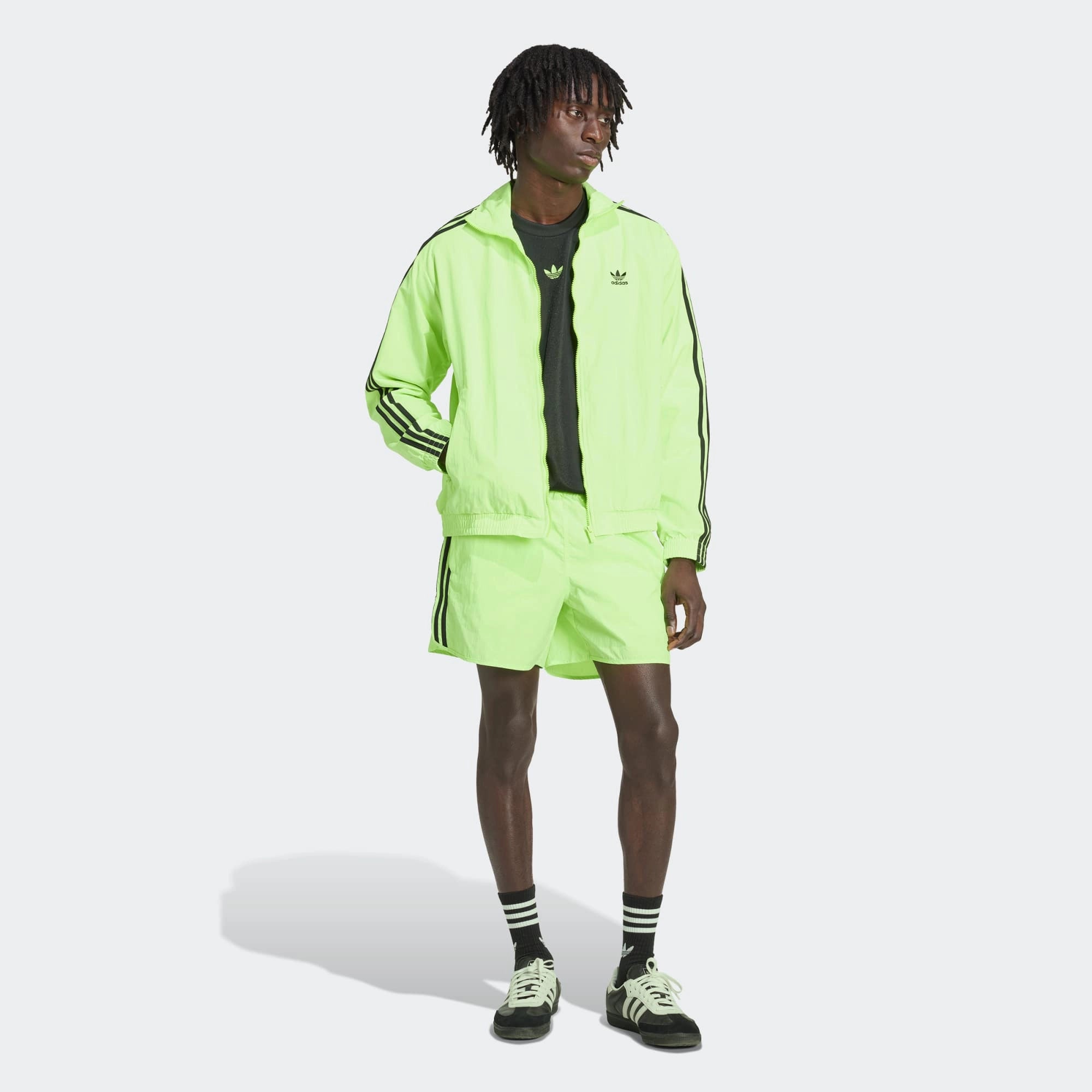 “Adidas Classics Sprinter Shorts in Signal Green – Kurze Retro-Sporthose mit schwarzen 3-Streifen, Trefoil-Logo und Reißverschlusstaschen bei Stickabush Berlin.“