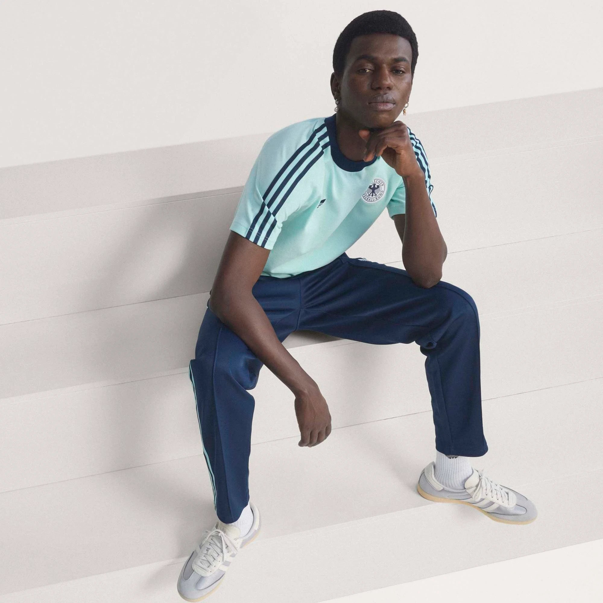 “Dunkelblaue adidas Originals DFB Deutschland OG Trainingshose mit weißen Streifen und gesticktem DFB-Adler Logo bei Stickabush.“