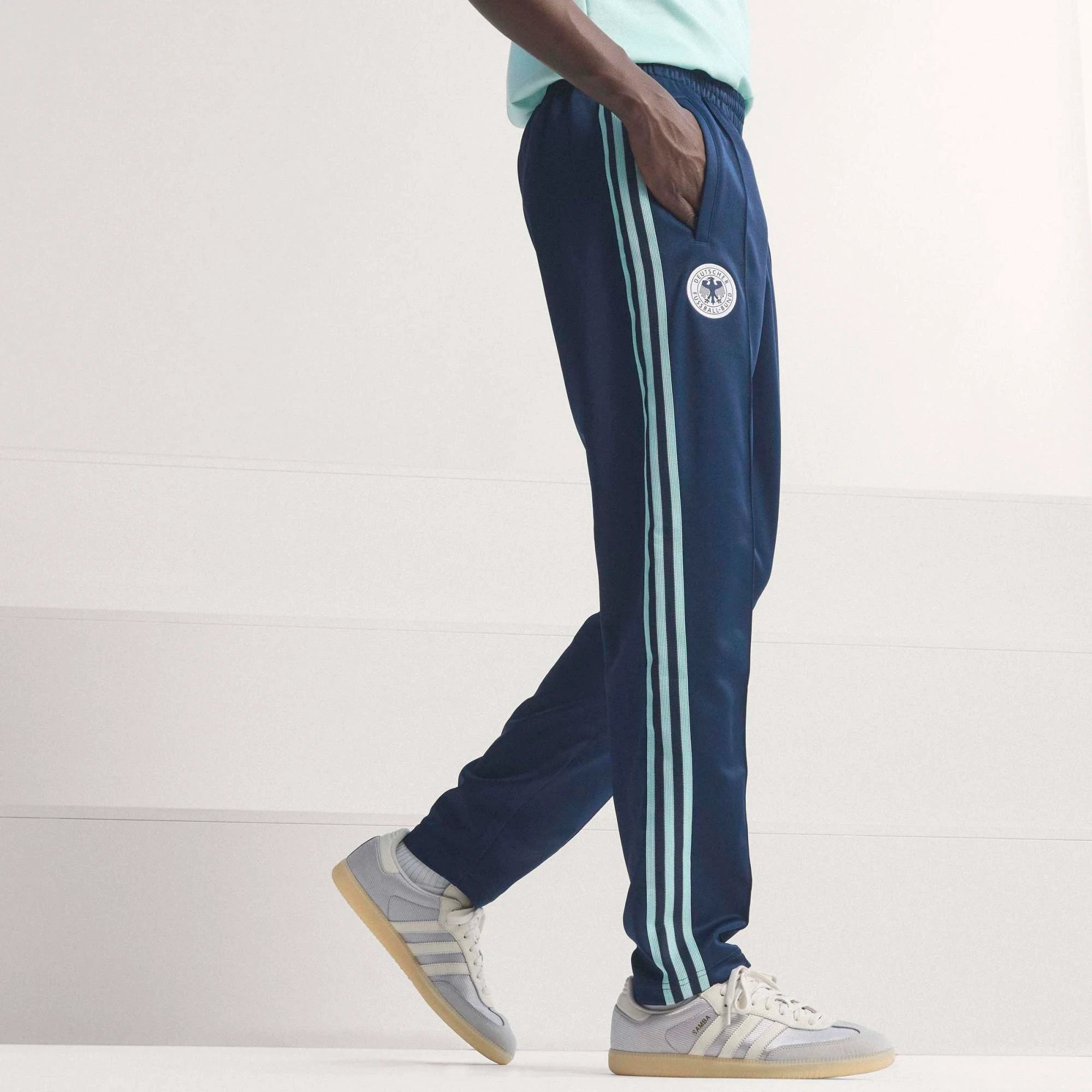 “Dunkelblaue adidas Originals DFB Deutschland OG Trainingshose mit weißen Streifen und gesticktem DFB-Adler Logo bei Stickabush.“
