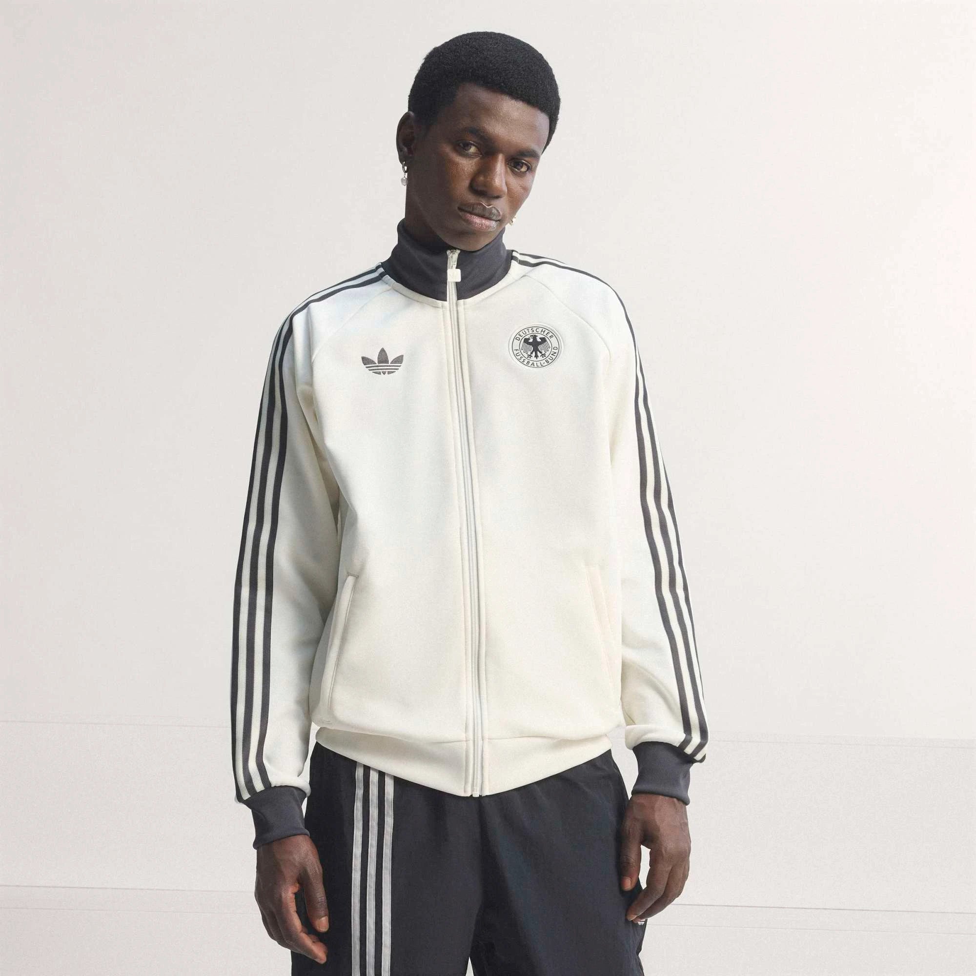 “Cremeweiße adidas Originals DFB Deutschland OG Trainingsjacke mit schwarzen Streifen und gesticktem DFB-Logo bei Stickabush.“