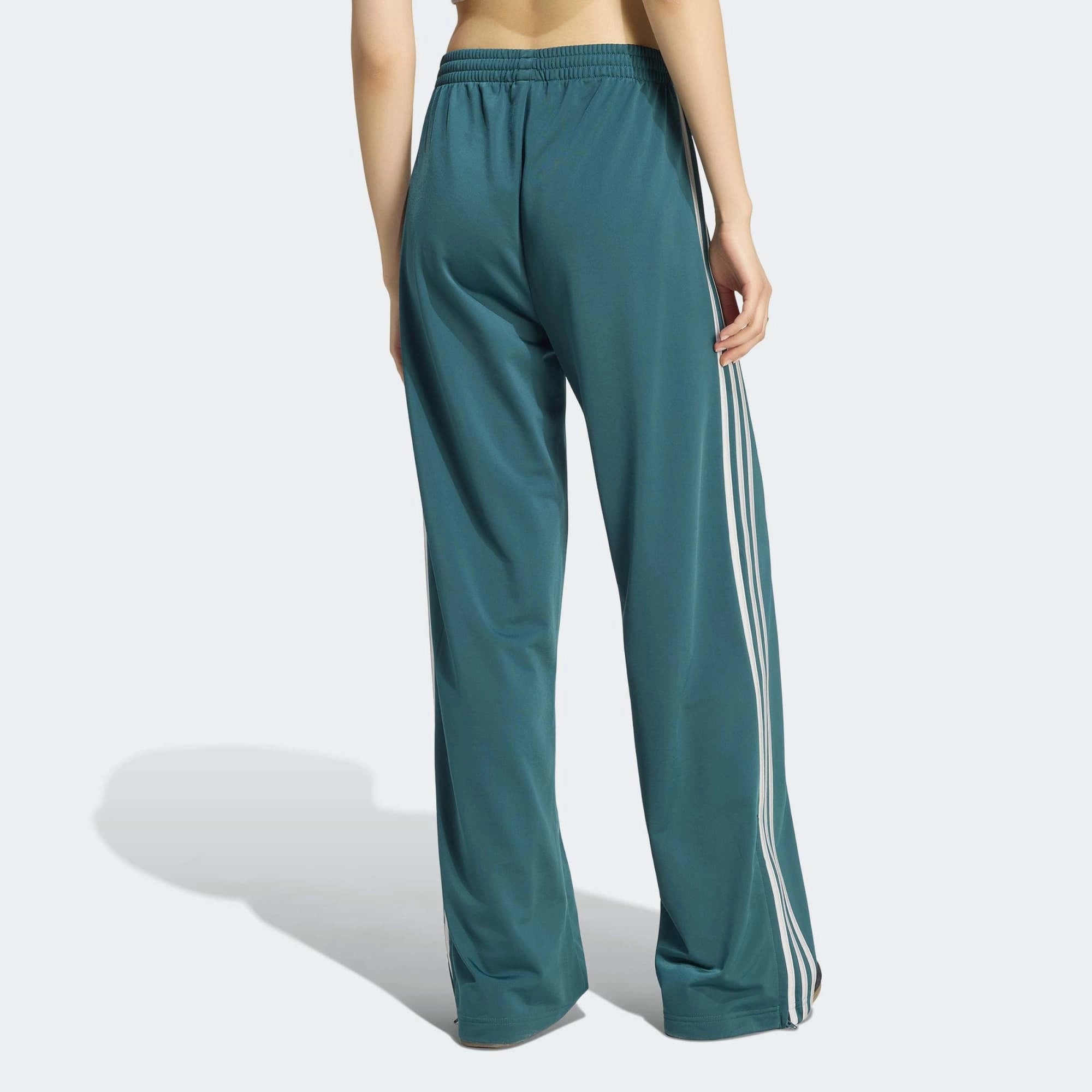 „Dunkelgrüne adidas Originals Firebird Loose Damen Track Pants (KS4672) mit grauen Streifen – weit geschnittene Retro-Trainingshose erhältlich bei Stickabush Berlin.“