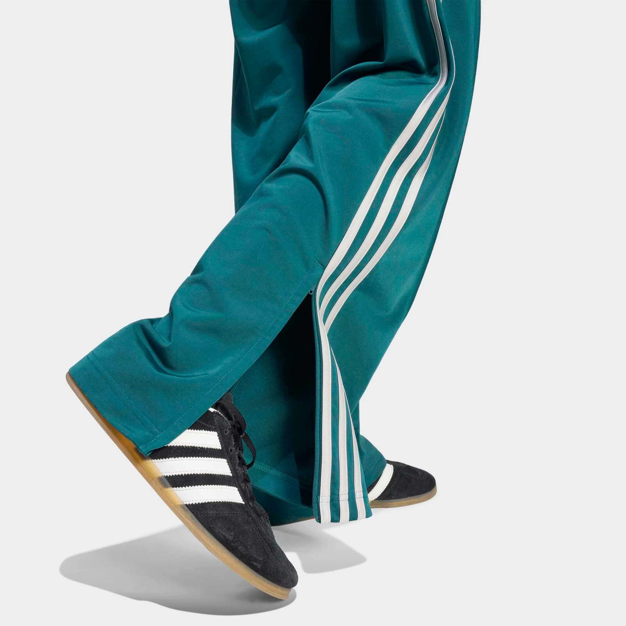 „Dunkelgrüne adidas Originals Firebird Loose Damen Track Pants (KS4672) mit grauen Streifen – weit geschnittene Retro-Trainingshose erhältlich bei Stickabush Berlin.“