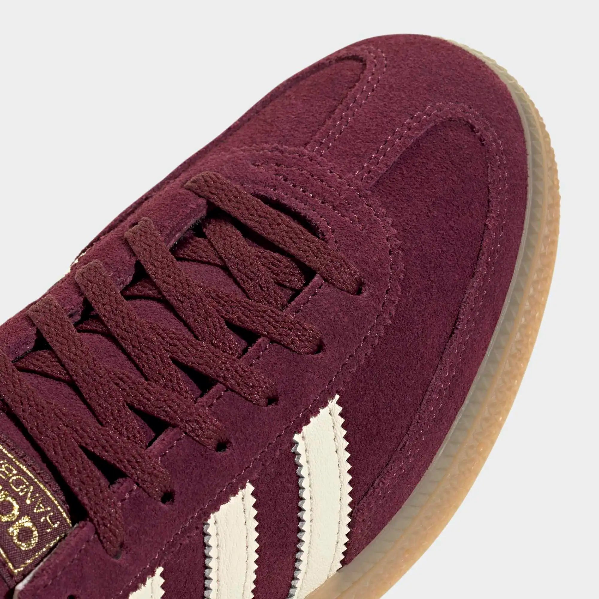 “Weinroter adidas Originals Handball Spezial Damen Sneaker (Maroon) mit cremeweißen Streifen und Naturgummi-Sohle bei Stickabush.“