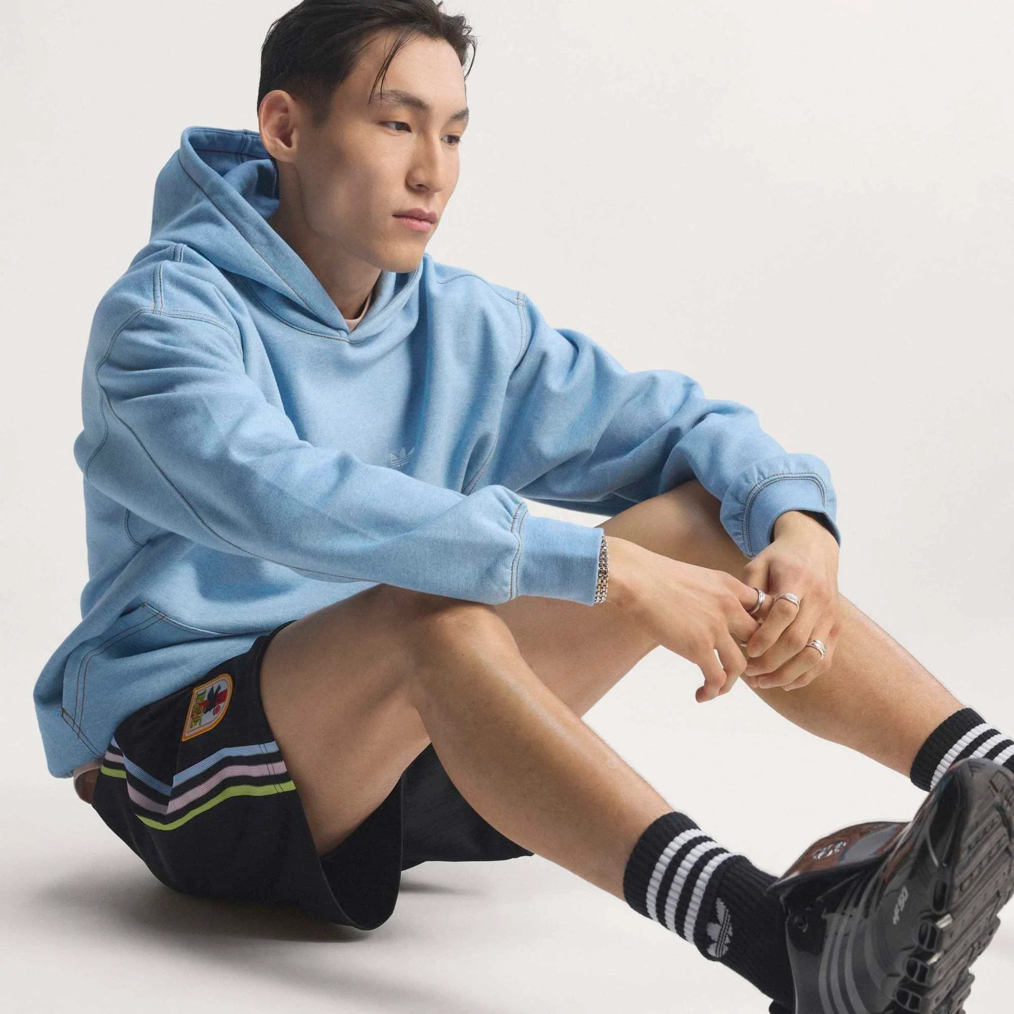 “Schwarze adidas Originals Japan OG Shorts mit weißen Streifen und dem gestickten JFA Japan Verbandswappen bei Stickabush.“