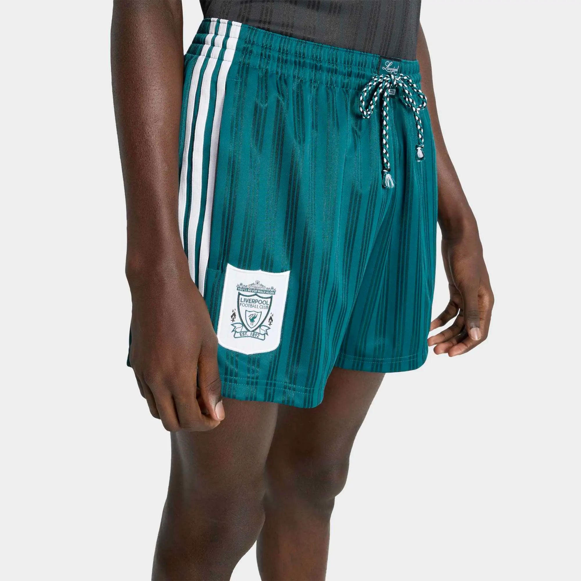 “Grün-weiße adidas Originals Liverpool FC 1995-96 Retro Shorts mit gesticktem Trefoil und Vereinswappen – Klassischer Quarter-Look bei Stickabush.“