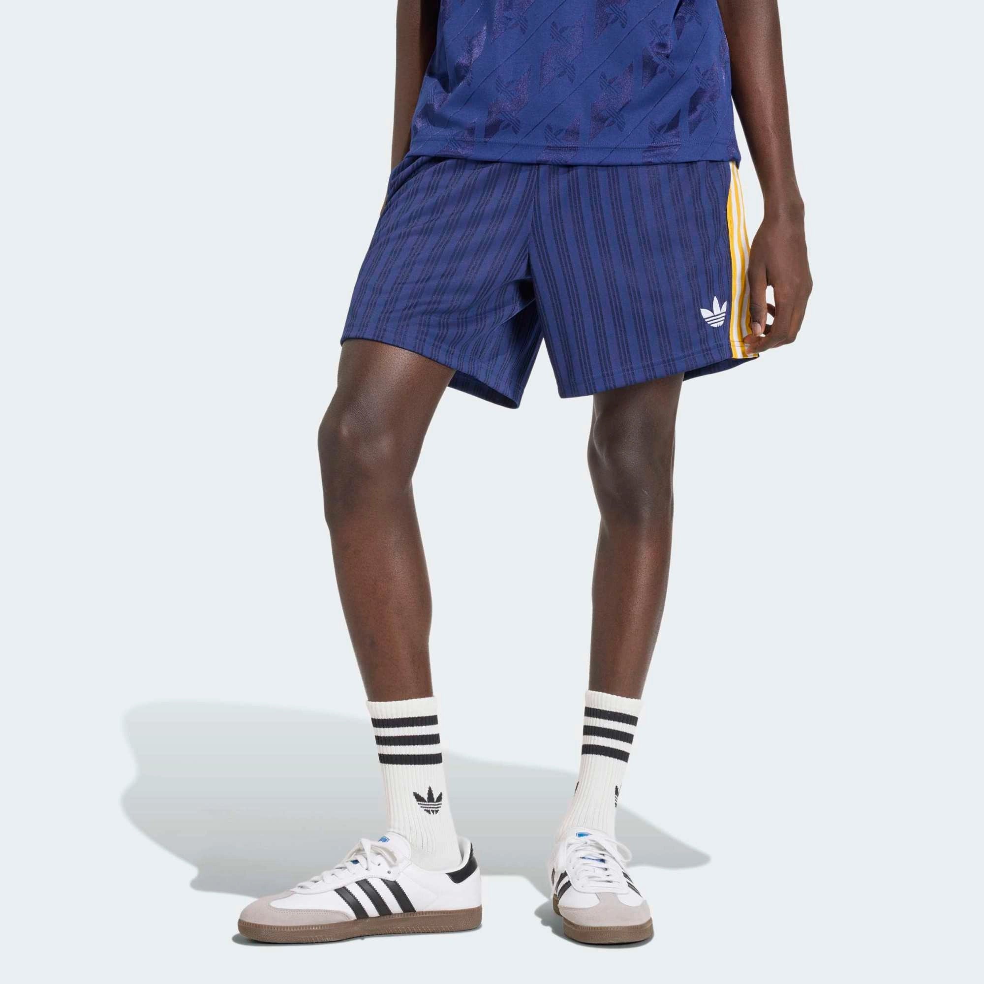 “Dunkelblaue adidas Originals Real Madrid Shorts mit gesticktem Trefoil-Logo und Vereinswappen – Klassischer Retro-Look bei Stickabush.“